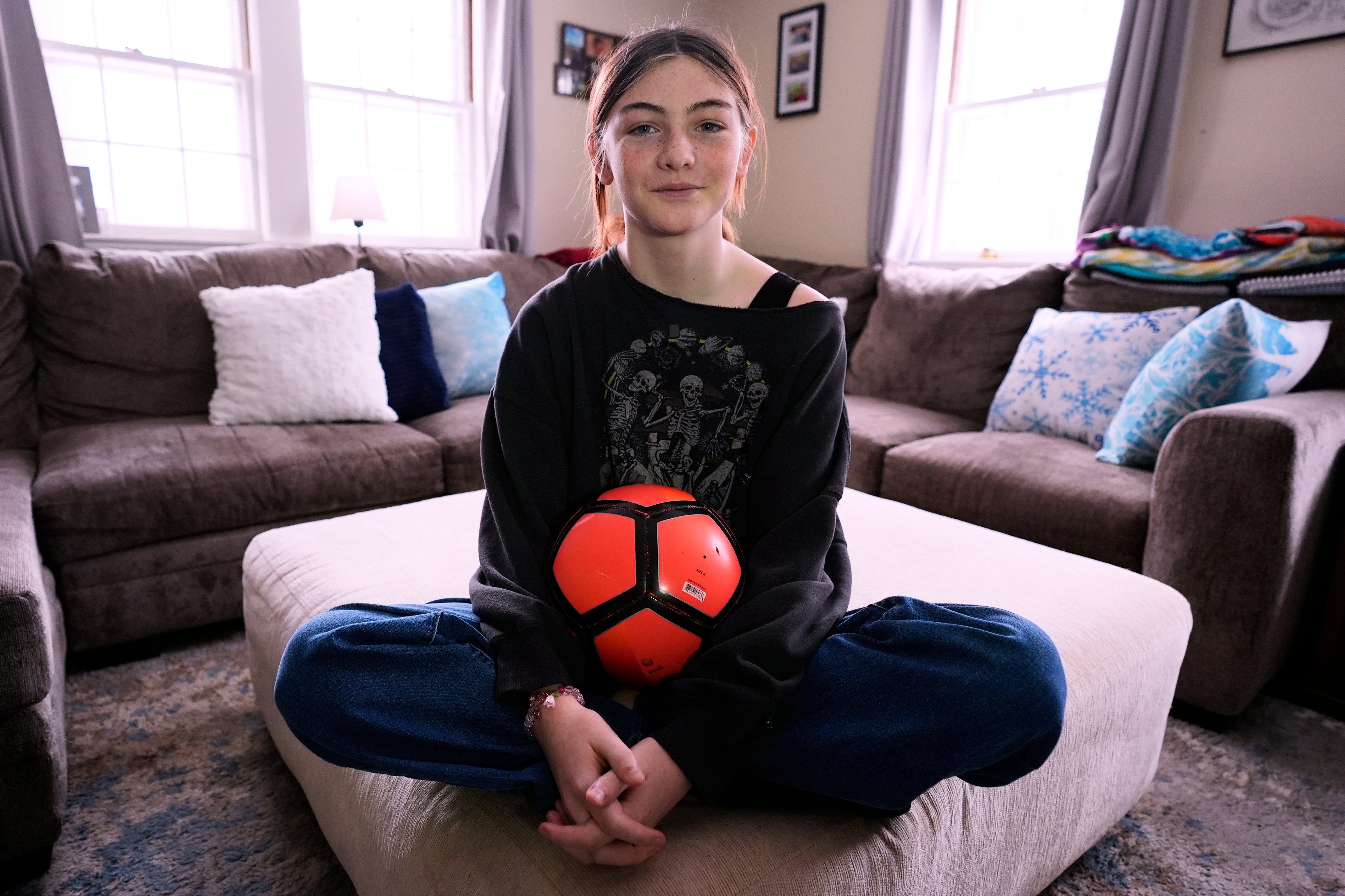 Parker Tirrell, a transgender athlete who plays on her high school's girls soccer team, poses in the living room of her family home, Friday, March 7, 2025, in Plymouth, N.H. (AP Photo/Charles Krupa)