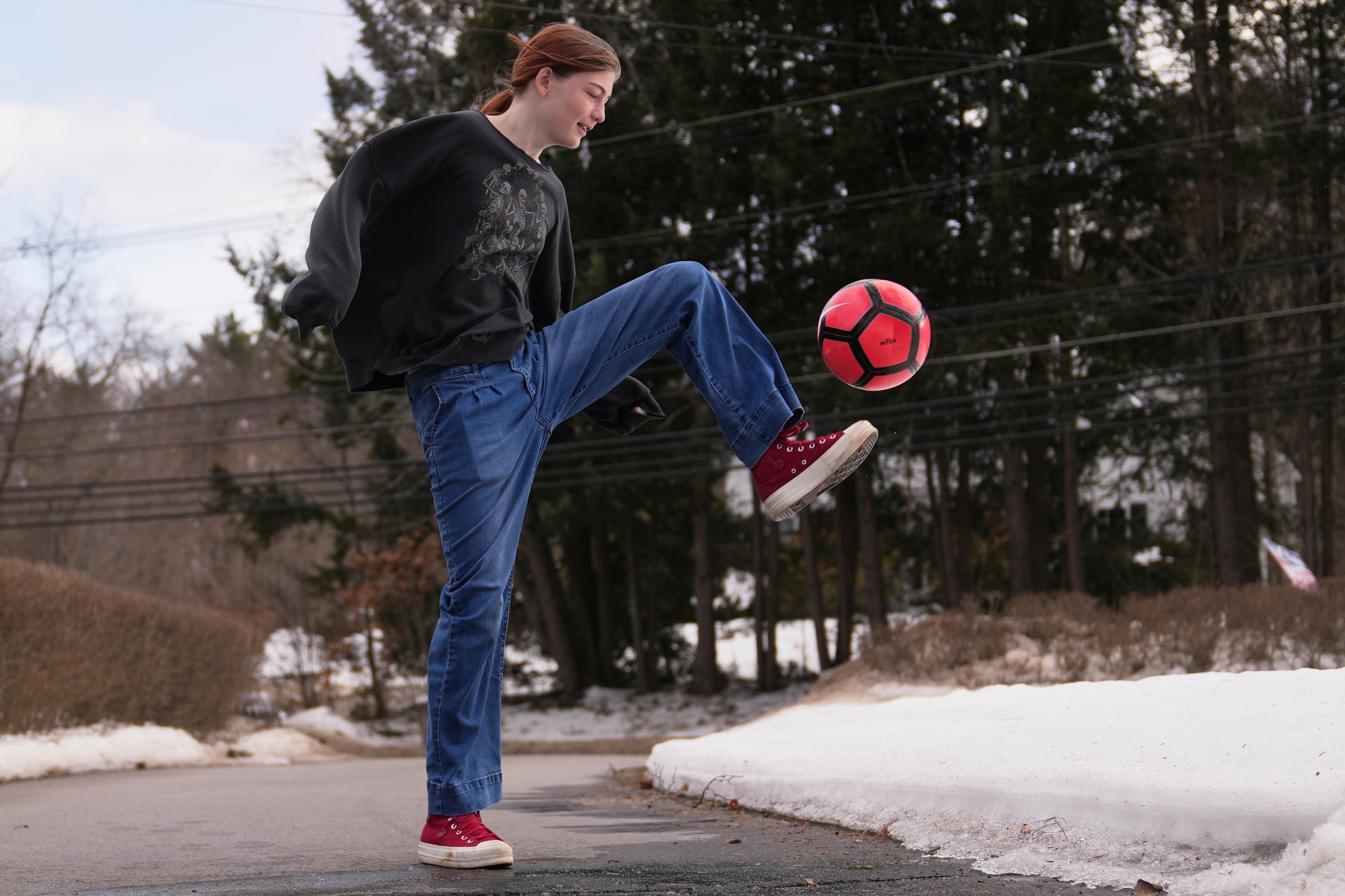 Parker Tirrell, a transgender athlete who plays on her high school's girls soccer team, practices in the driveway of her family home, Friday, March 7, 2025, in Plymouth, N.H. (AP Photo/Charles Krupa)