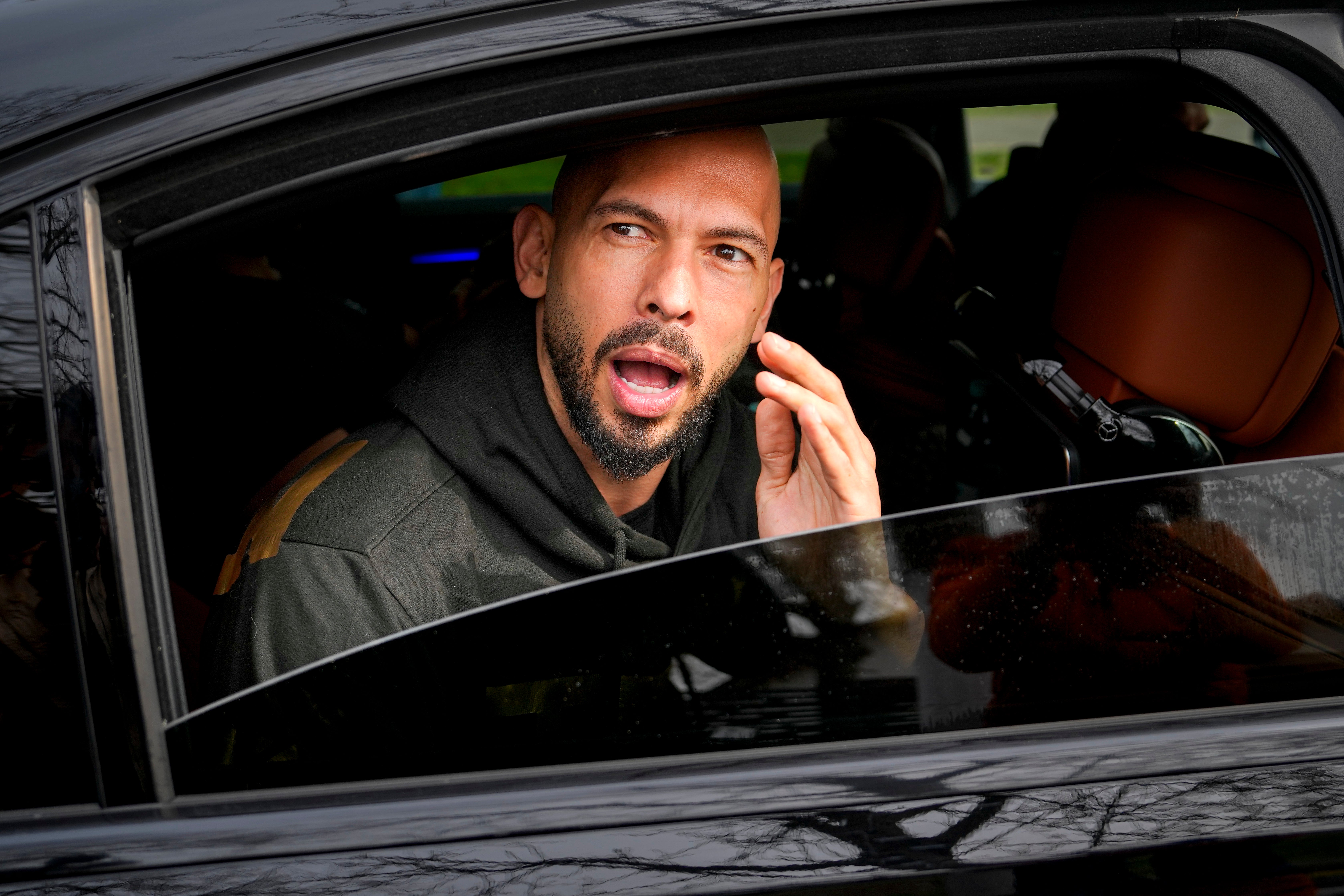 Andrew Tate gestures while speaking to media after checking in at a police station as part of his judicial control, which requires him to appear before judicial authorities in Romania (AP/Vadim Ghirda)