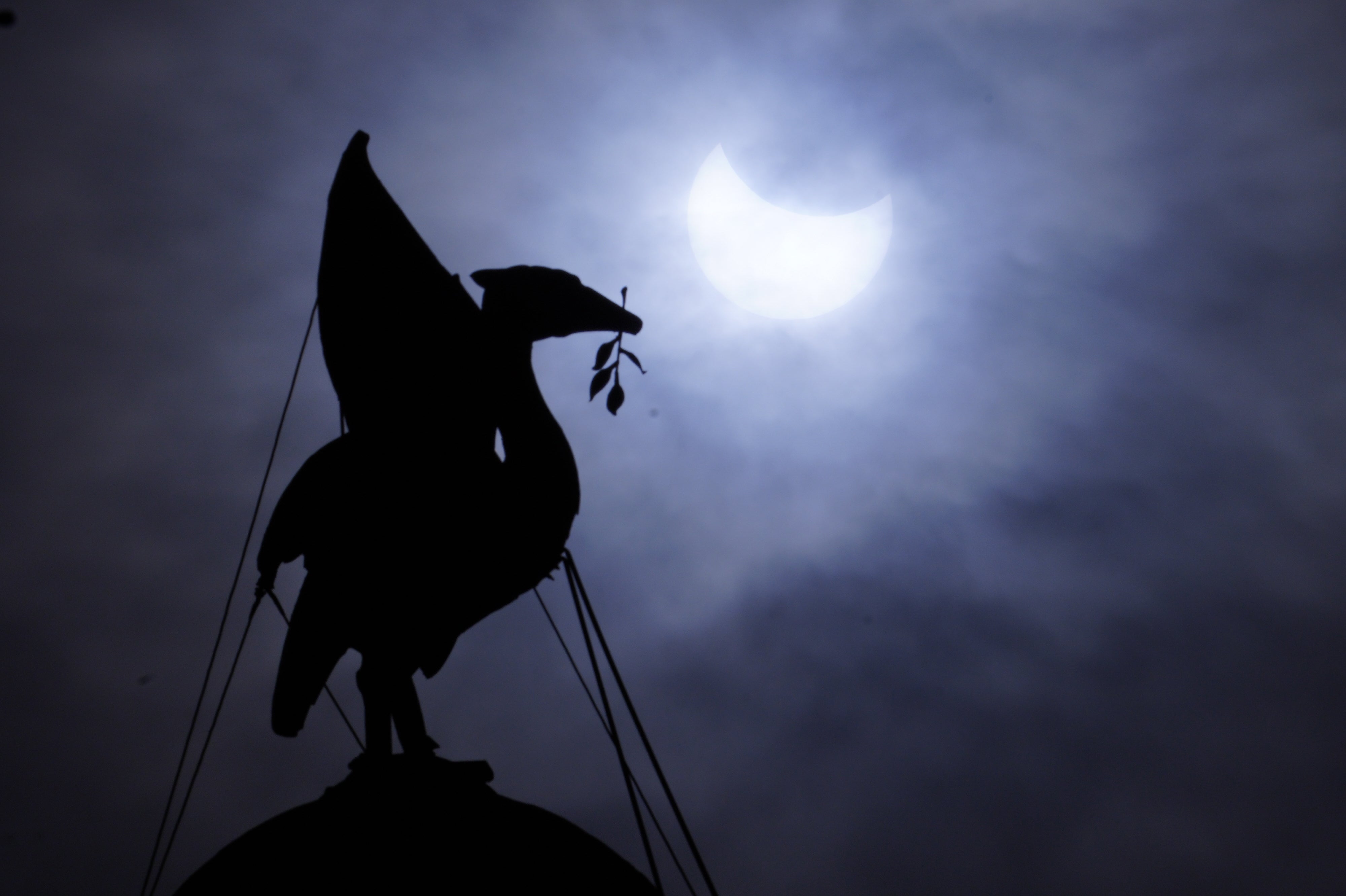 The partial solar eclipse as seen over The Royal Liver Building on Liverpool’s waterfront (Peter Byrne/PA)