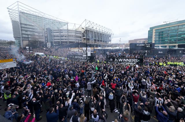 <p>The open top buses carrying the Newcastle United players pass by fans outside St James’ Park during the Carabao Cup trophy parade in Newcastle (Owen Humphreys/PA)</p>
