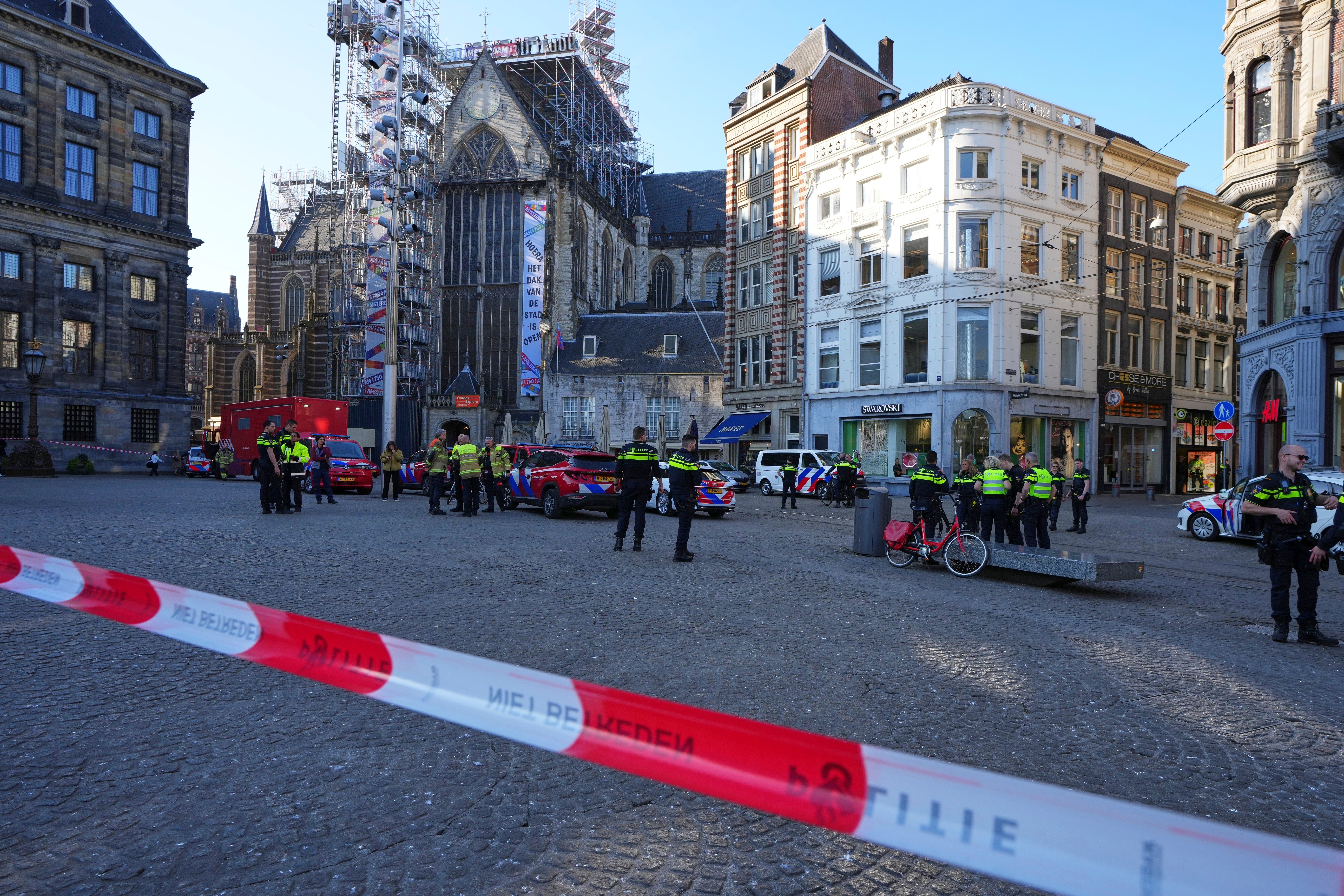 Police officers stand behind a cordoned off area after a stabbing near Dam Square in central Amsterdam on Thursday (Peter Delong/AP)