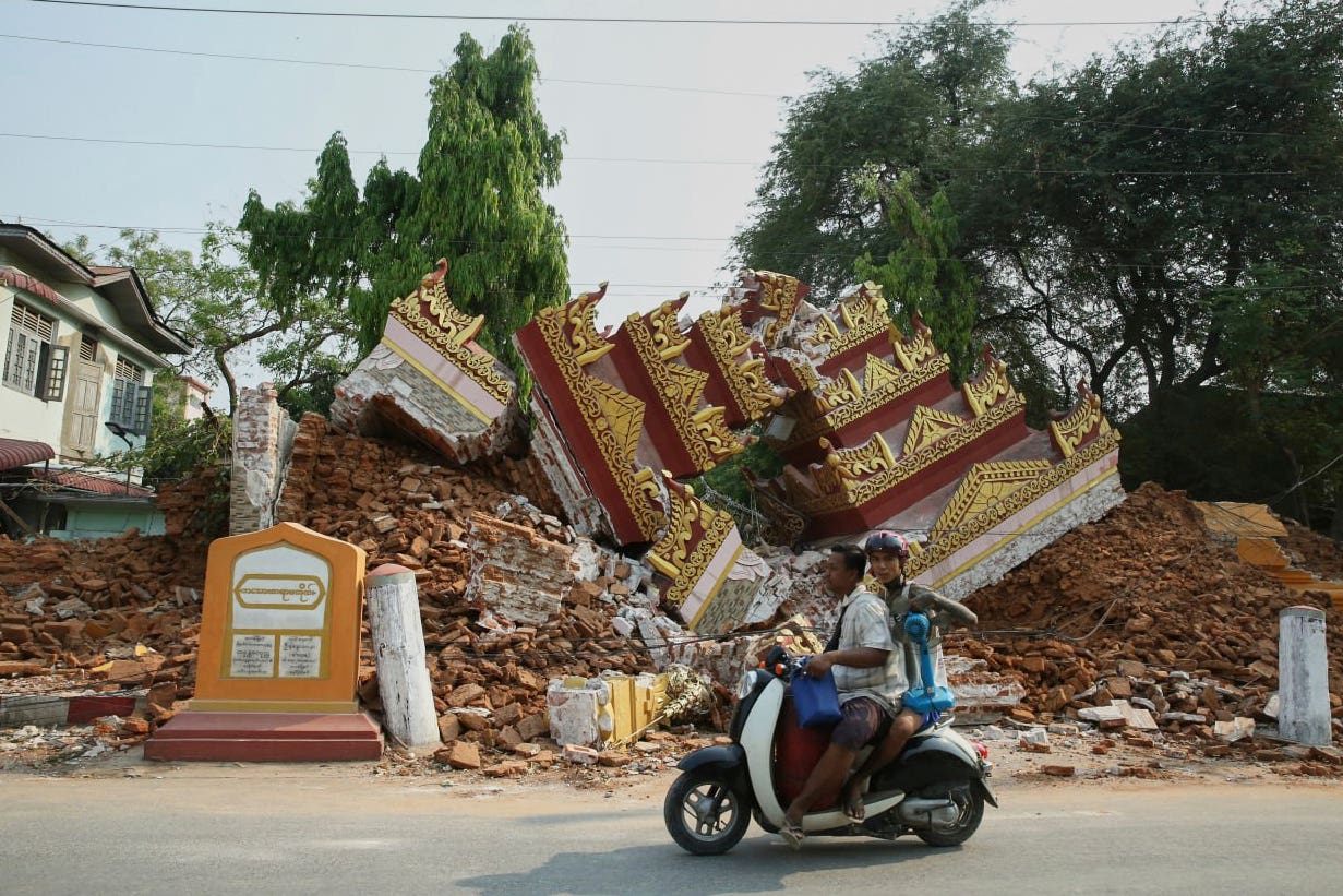 Locals pass by a collapsed building in the aftermath of an earthquake in Mandalay, Myanmar (Myo Kyaw Soe/Xinhua via AP)
