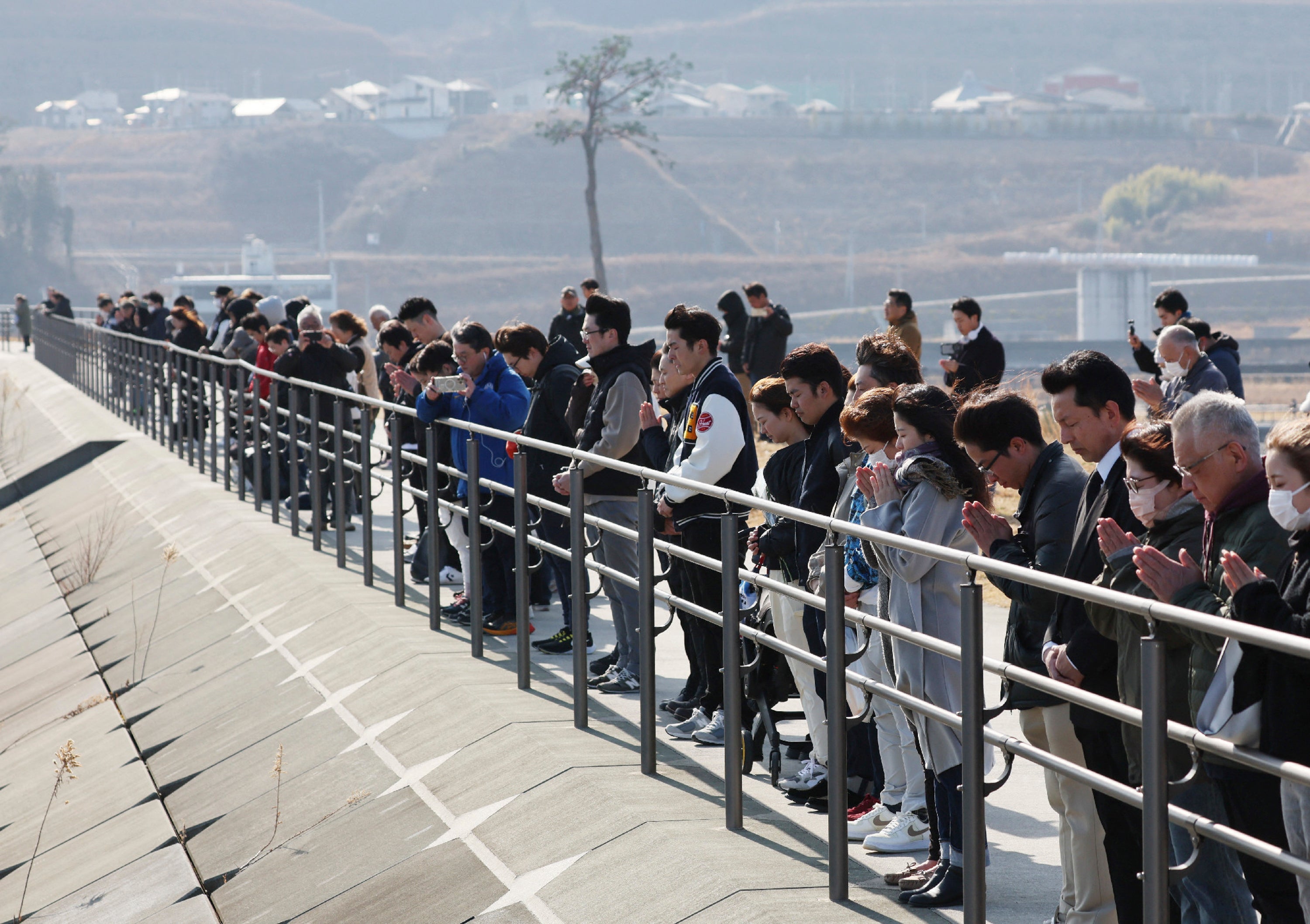 People observe a minute of silence to remember the victims of the 2011 earthquake, tsunami and nuclear disaster in Rikuzentakata city of Iwate prefecture, Japan, on 11 March 2025