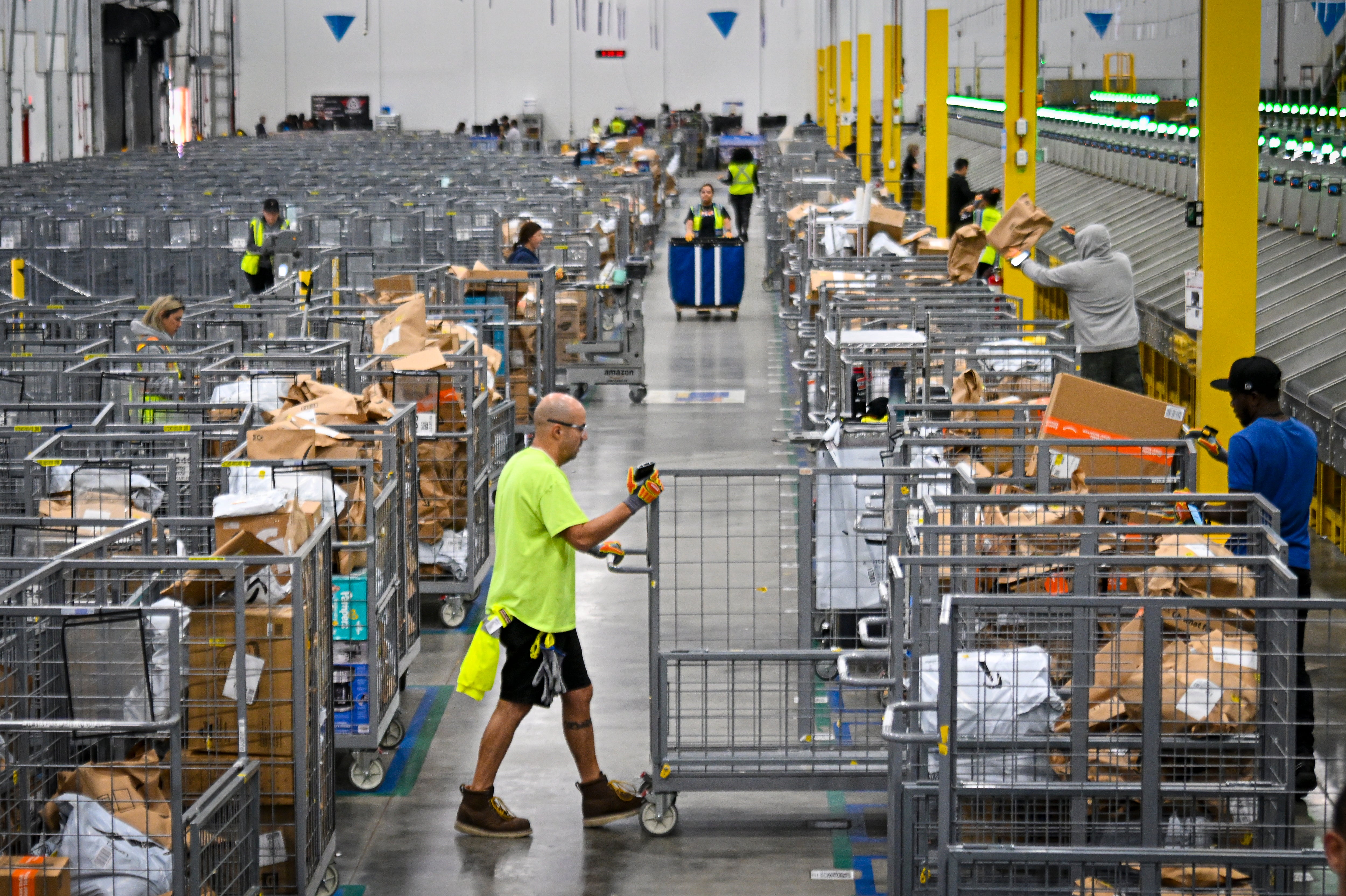 President Donald Trump’s tariff plan could have a major impact on prices for countless goods shipped into the U.S. Pictured: Workers in an Amazon warehouse prepare items to ship to customers