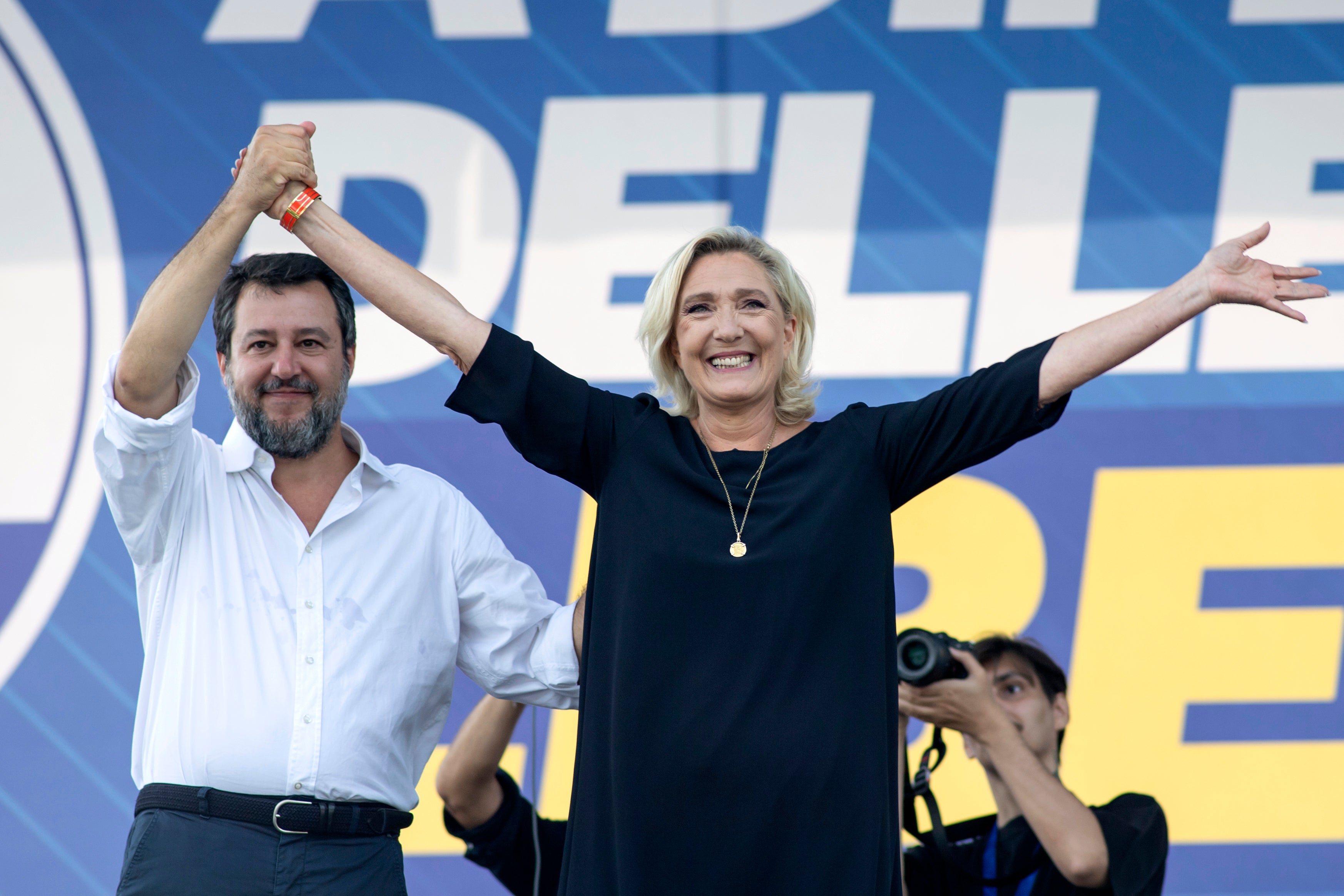 Matteo Salvini stands on stage with French right-wing leader Marine Le Pen