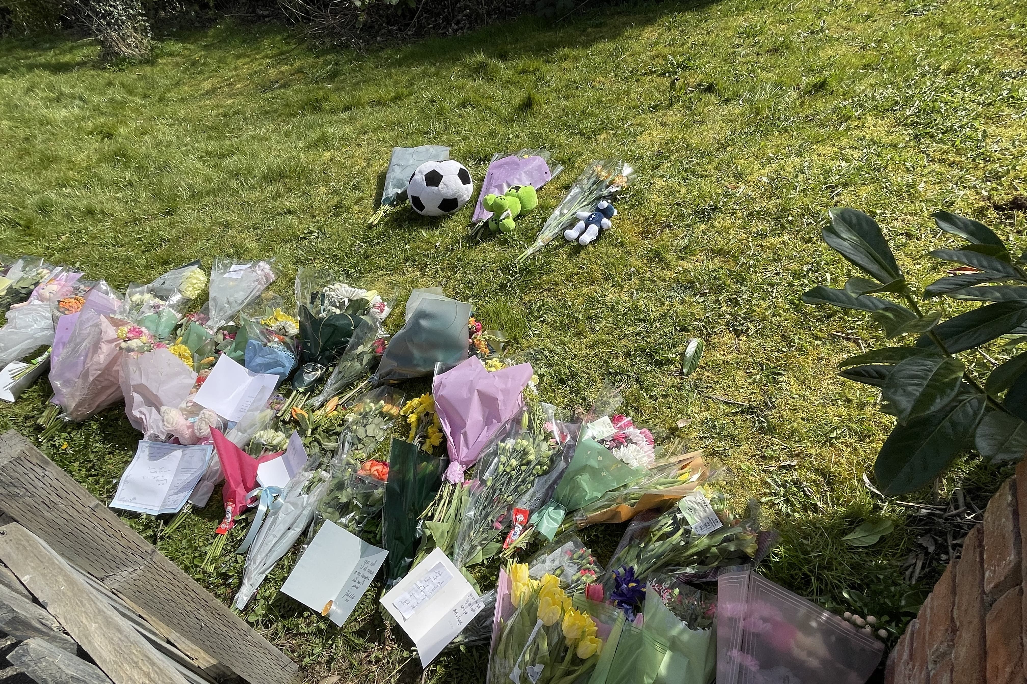 Floral tributes have been left for three people who died in a fire (Sophie Robinson/PA)