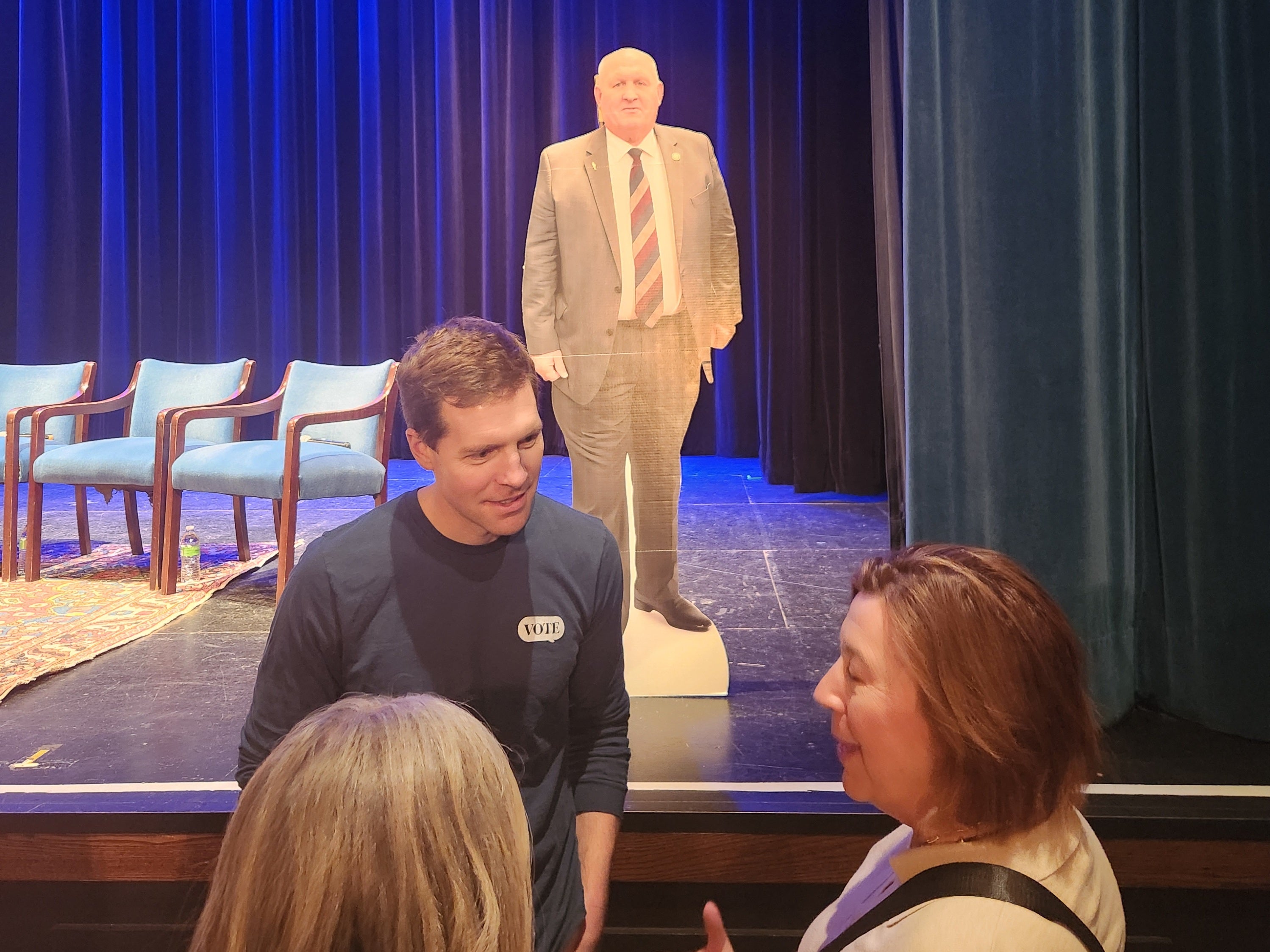 Conor Lamb, with a cardboard cutout of Congressman Glenn Thompson looming behind him, speaks to voters in Thompson's district outside of Penn State University