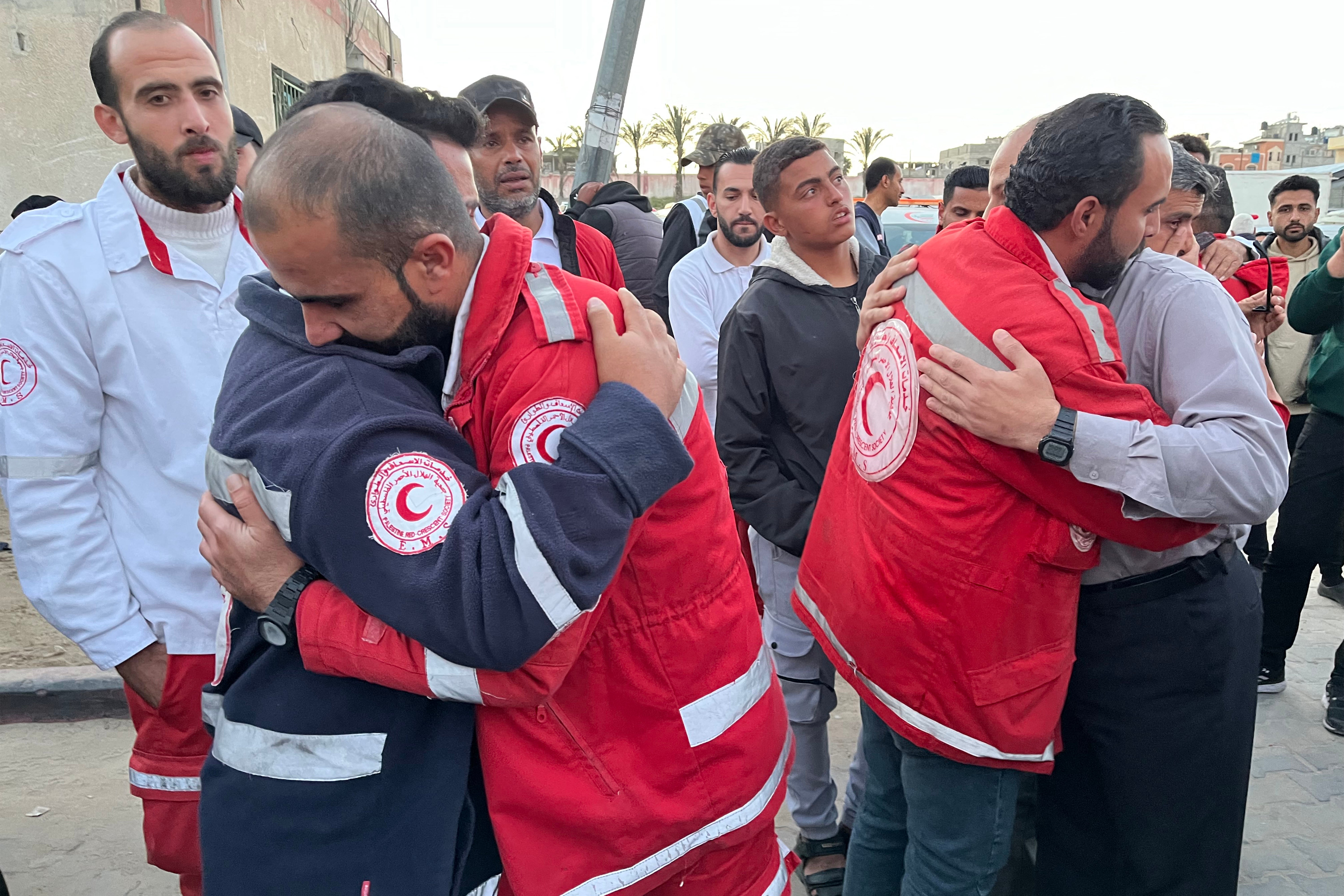 First responders embrace each other at Nasser Medical Complex in Khan Yunis in the southern Gaza Strip on Sunday as the bodies of Palestinian first responders who were killed a week before in Israeli military fire on ambulances arrive at the facility