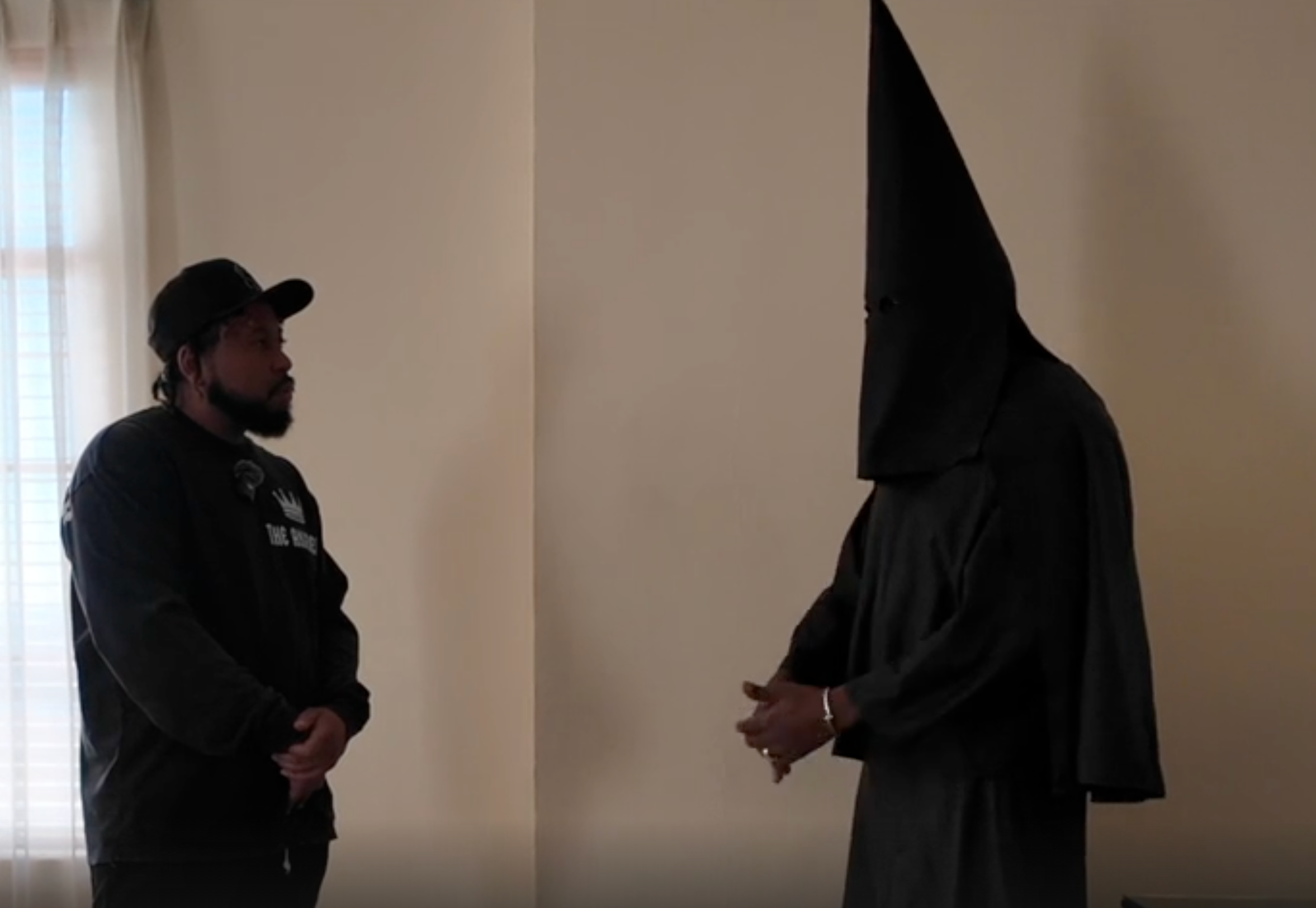 Kanye West wears a black KKK outfit during an interview with DJ Akademiks