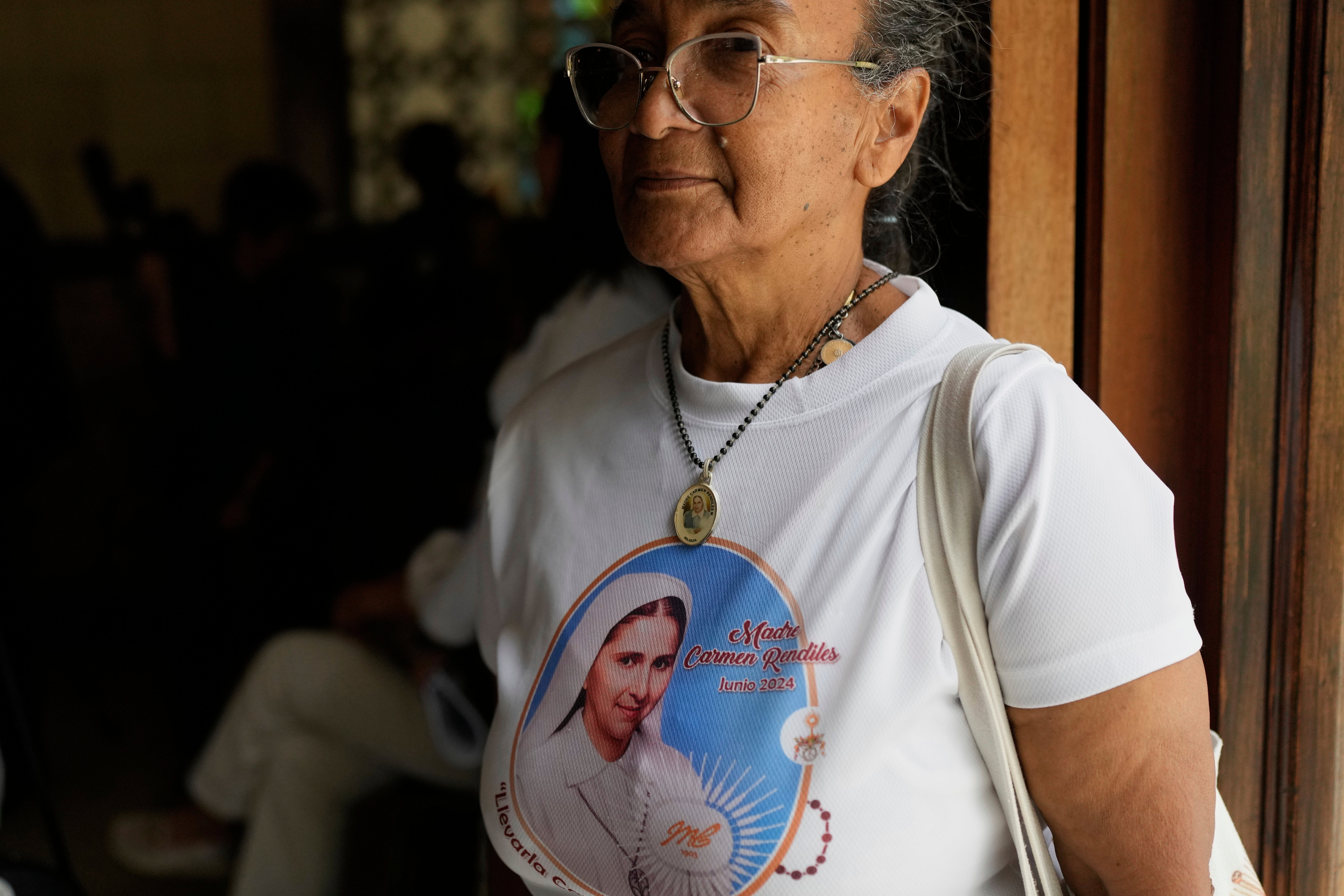 A believer attends a celebratory Mass for Blessed Maria Carmen Rendiles, wearing a T-shirt with her image
