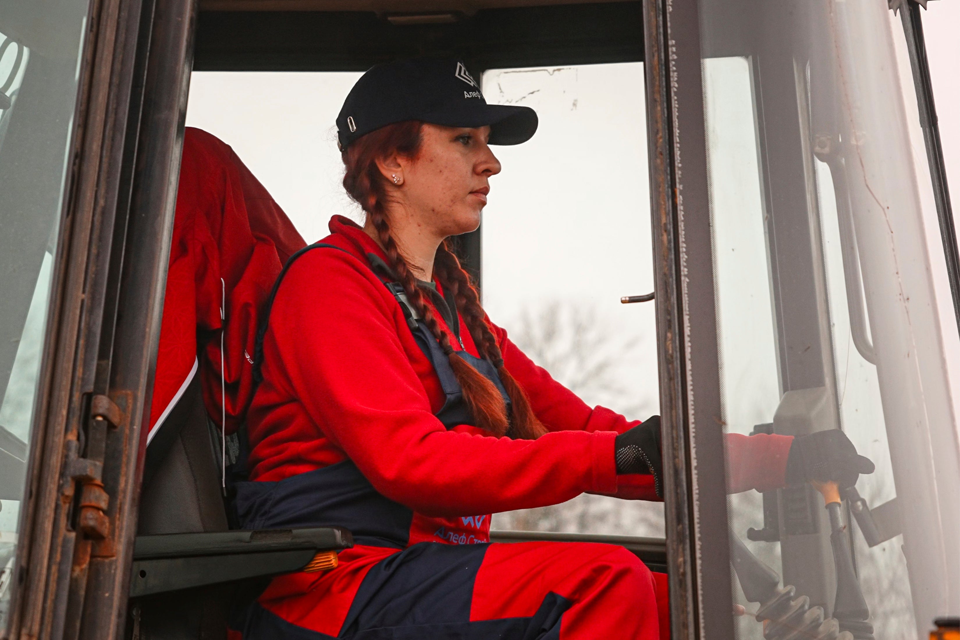 A woman operates an excavator during construction work in Nemishaieve, Kyiv region