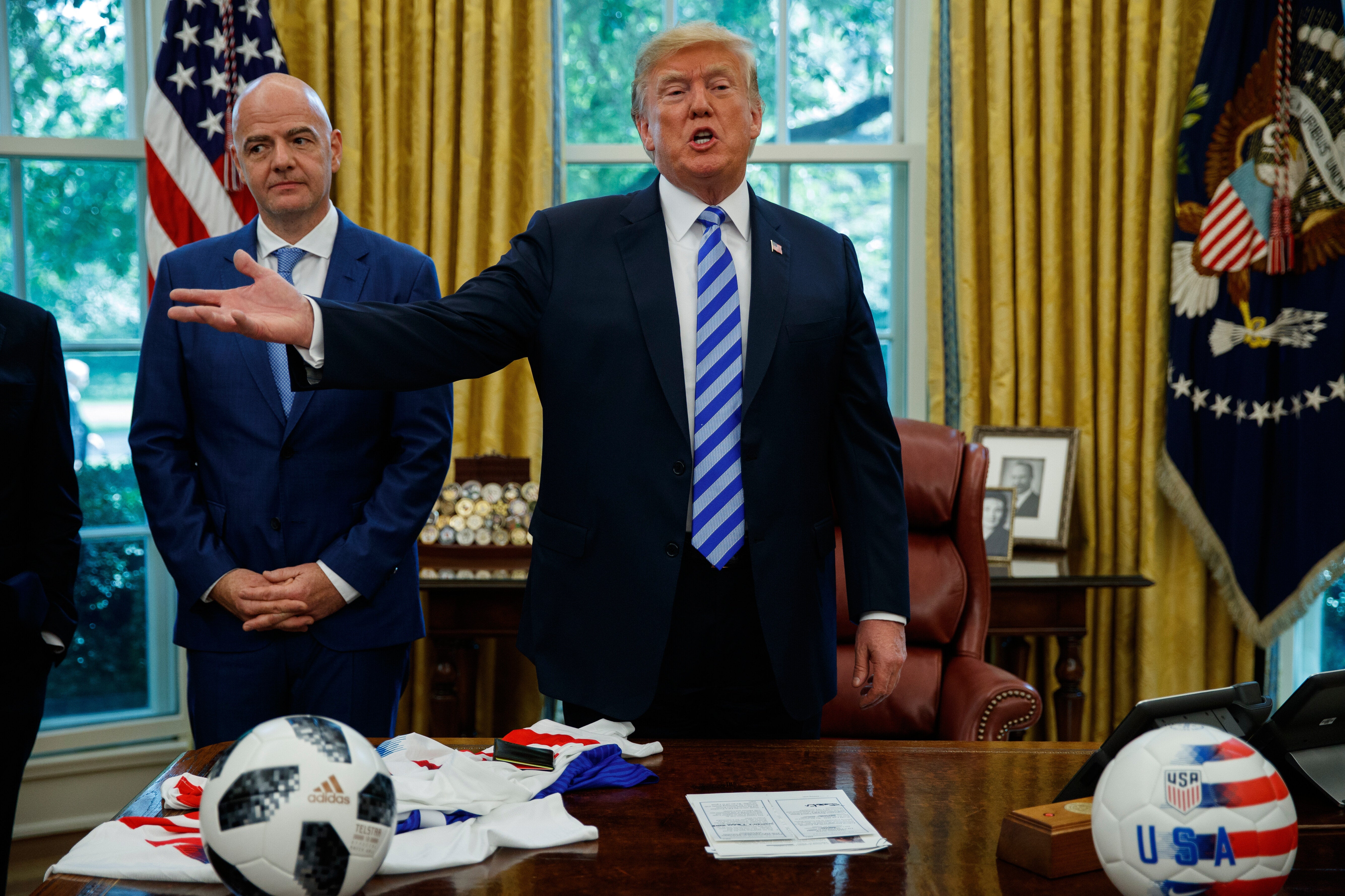 Fifa president Gianni Infantino, left, watches as President Donald Trump speaks to reporters during a meeting in the Oval Office