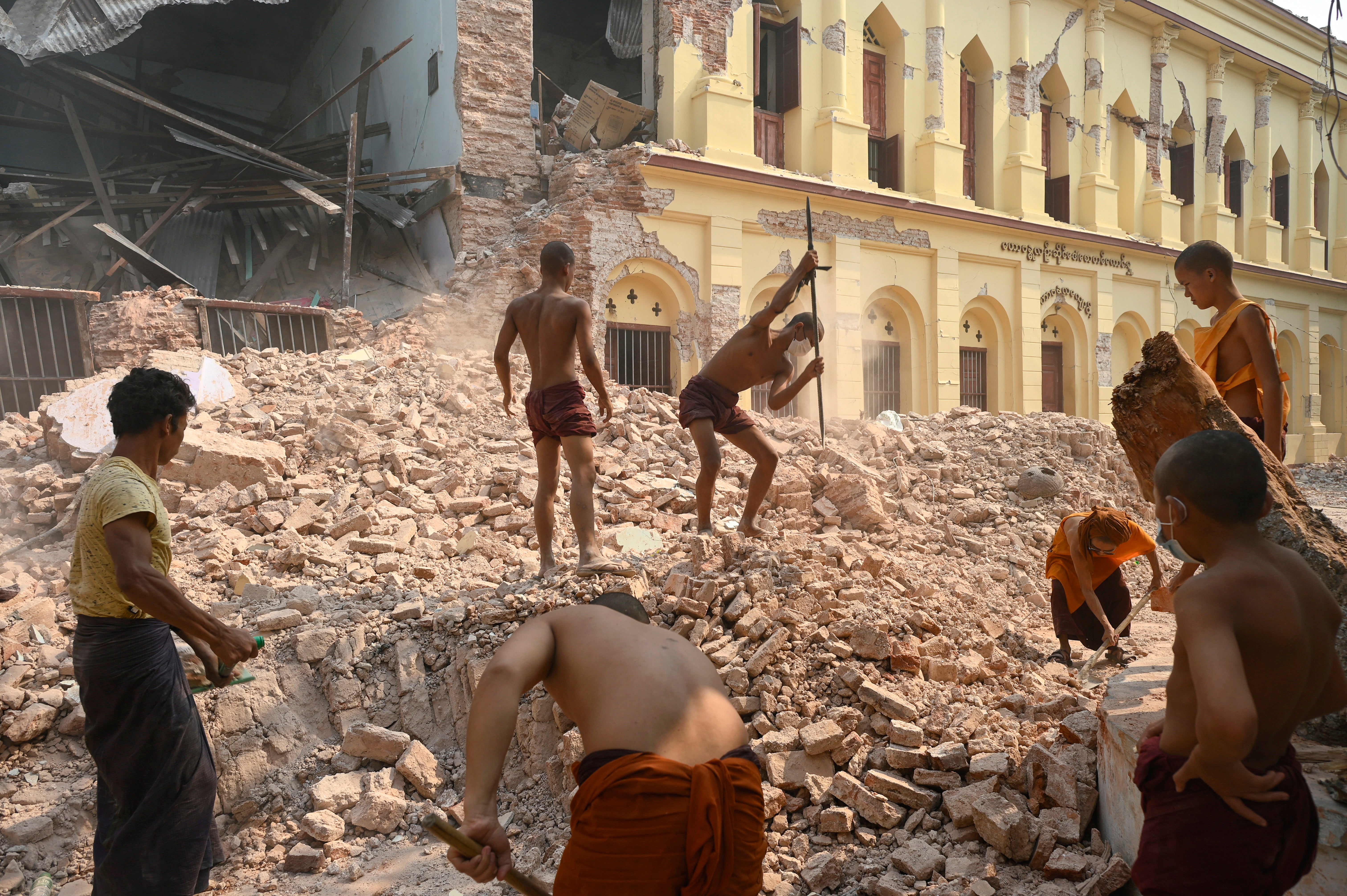 Buddhist monks clear up rubble at the damaged Thahtay Kyaung Monastery in Mandalay on 1 April, 2025, four days after a major earthquake struck central Myanmar