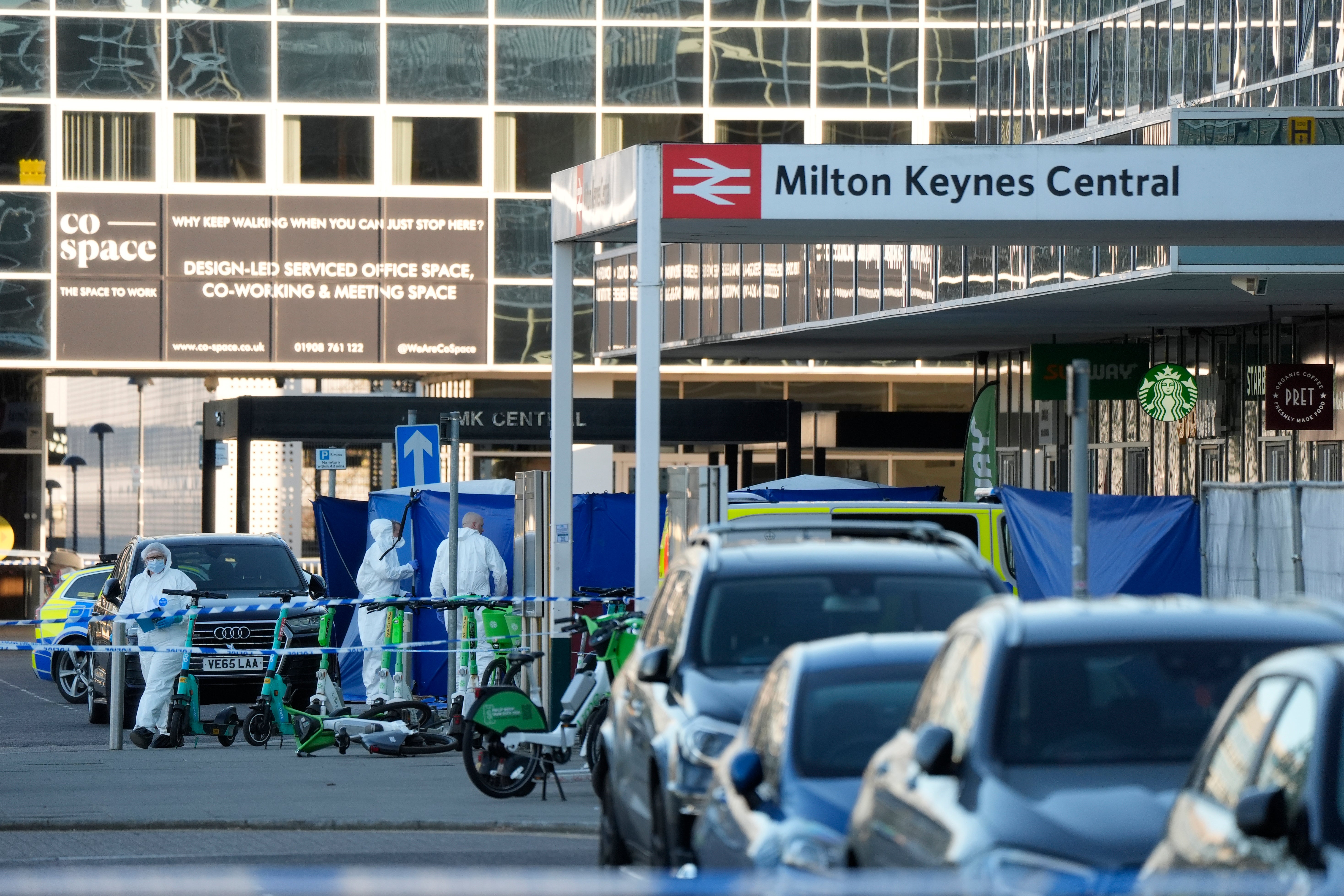 Forensics officers at Milton Keynes train station after a man was shot dead by armed police officers.