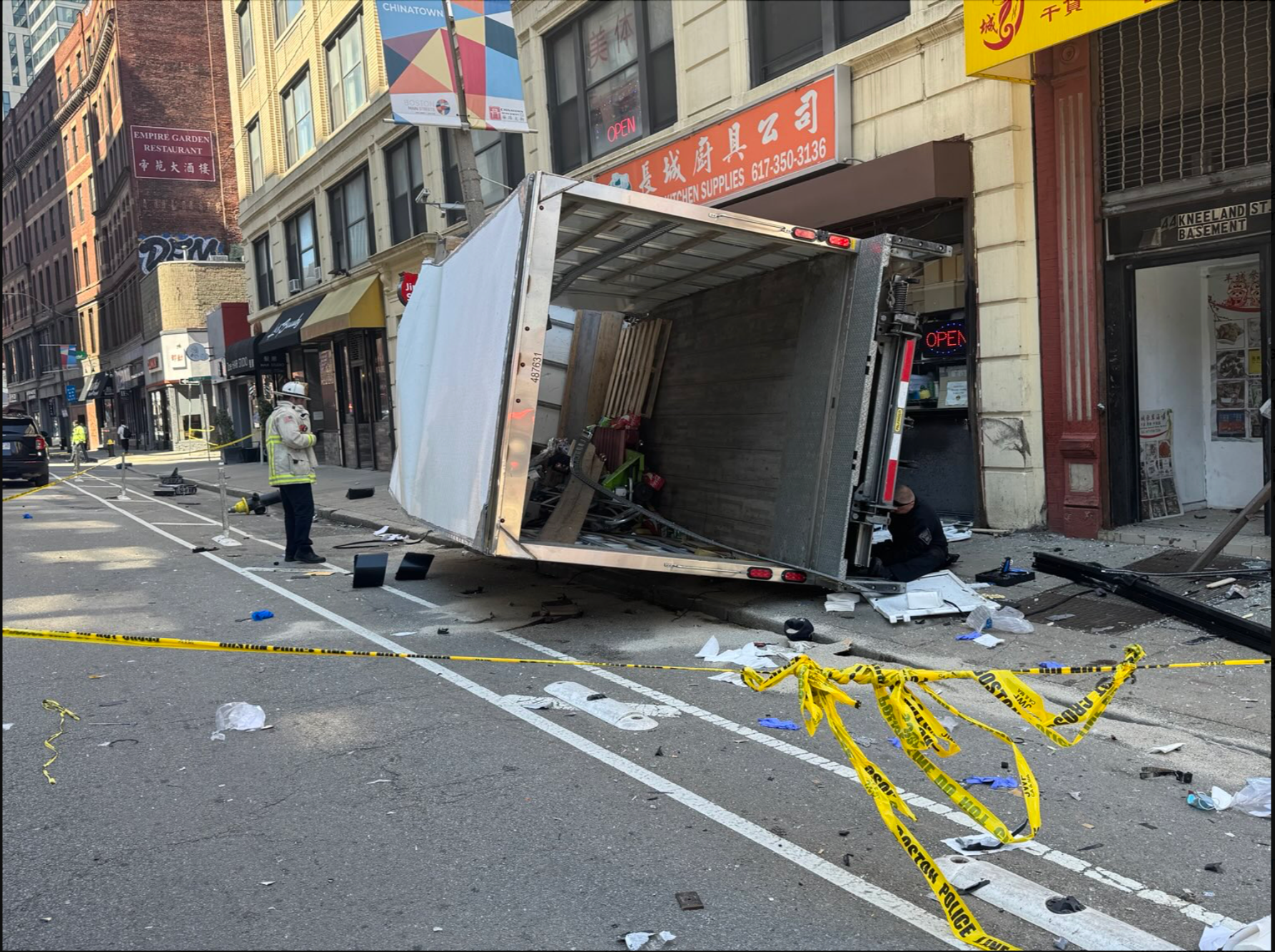 A truck rests against the side of a building in Boston's Chinatown. It crashed into people and left a total of six injured