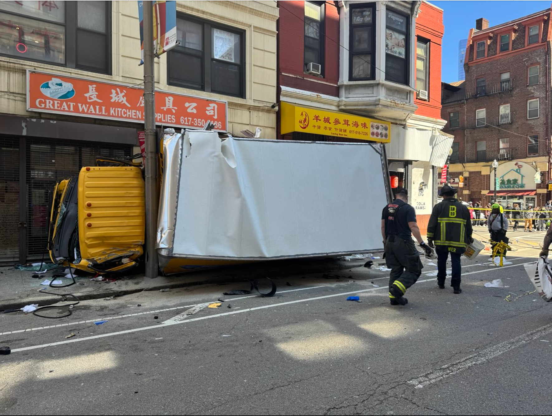 A Penske box rental truck is turned on its side outside of a store in Boston. There have been no reported deaths