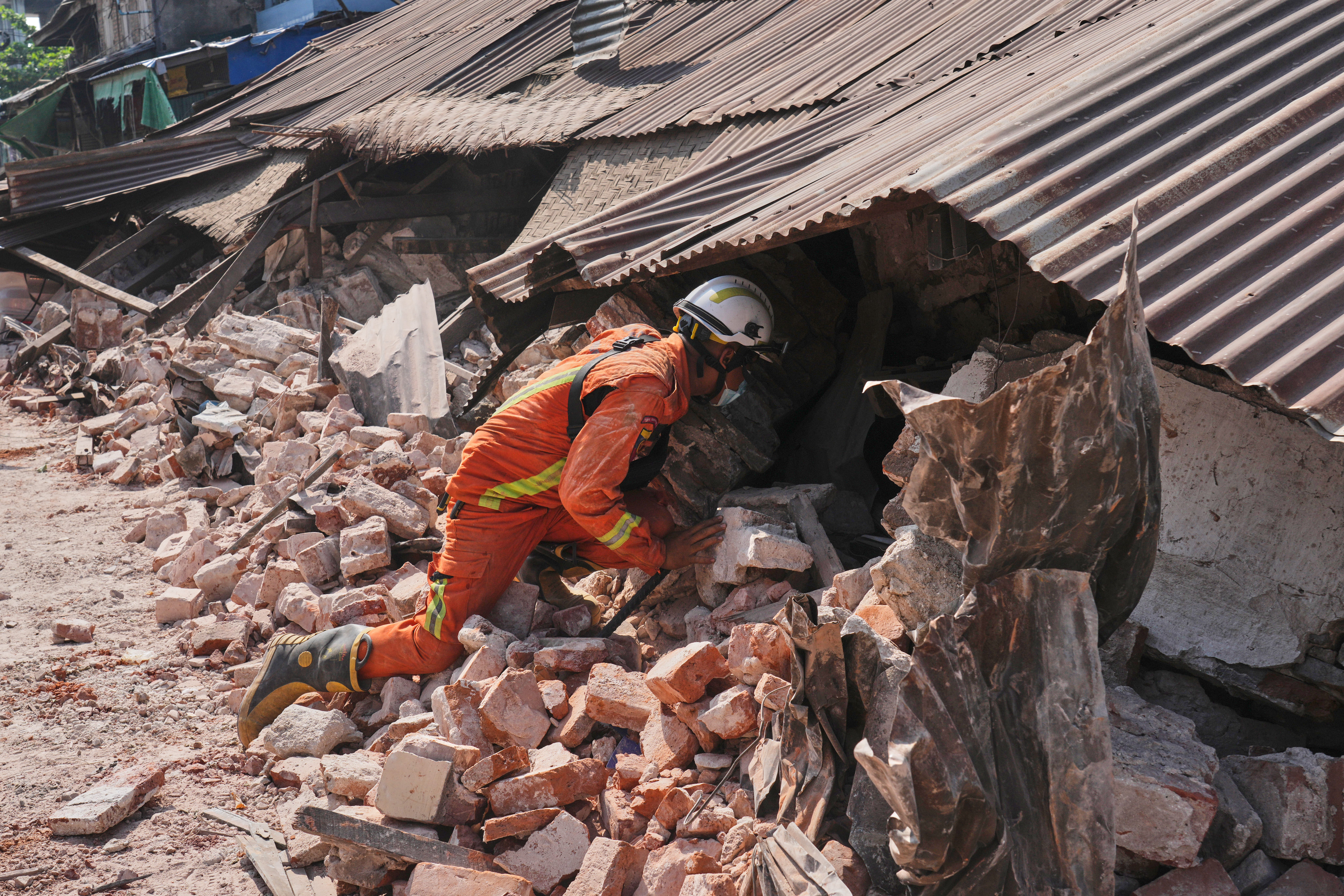File image of rescuer working through rubble of a collapsed building following the earthquake in Myanmar