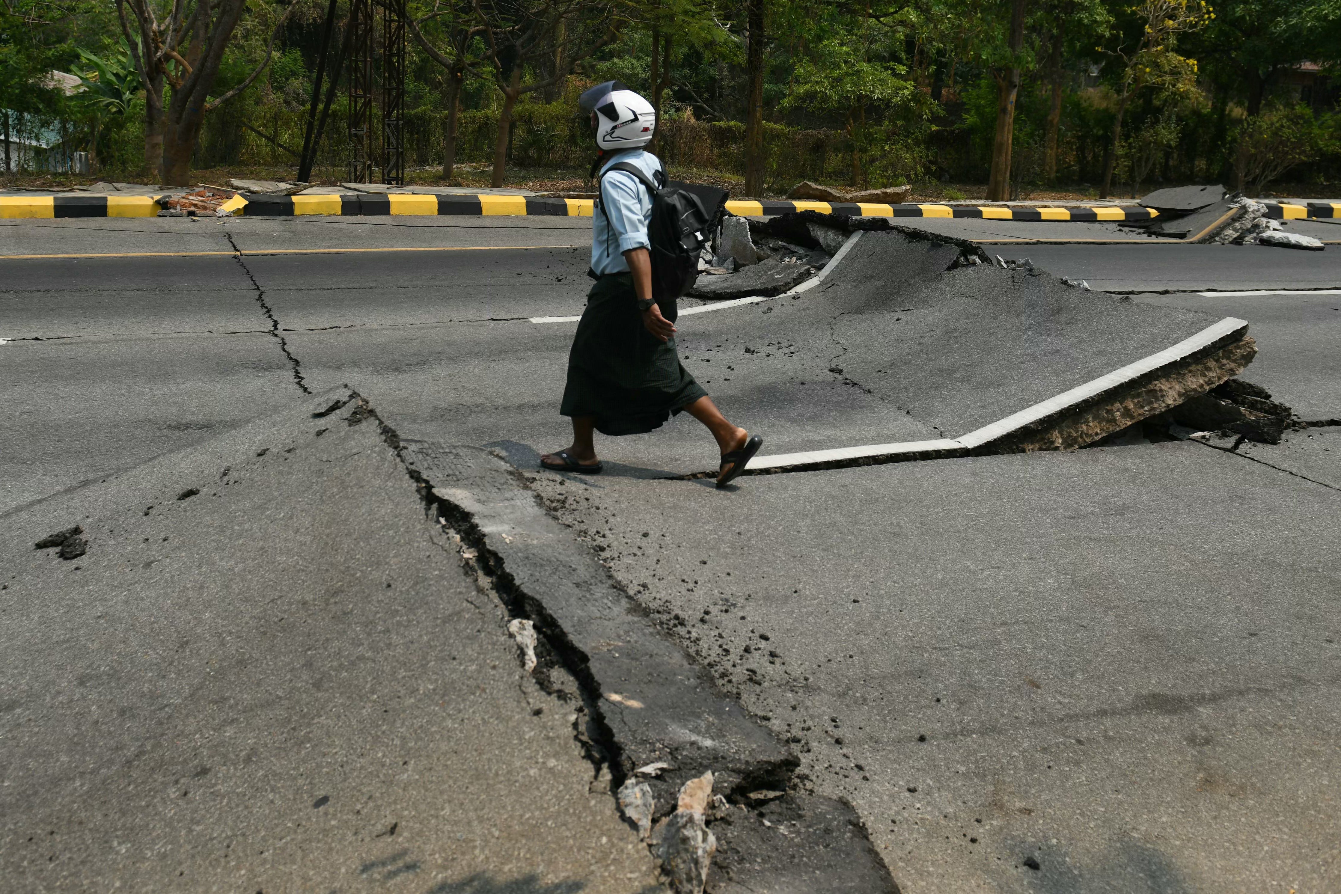 Man walks along a damaged road in Naypyidaw after an earthquake in central Myanmar