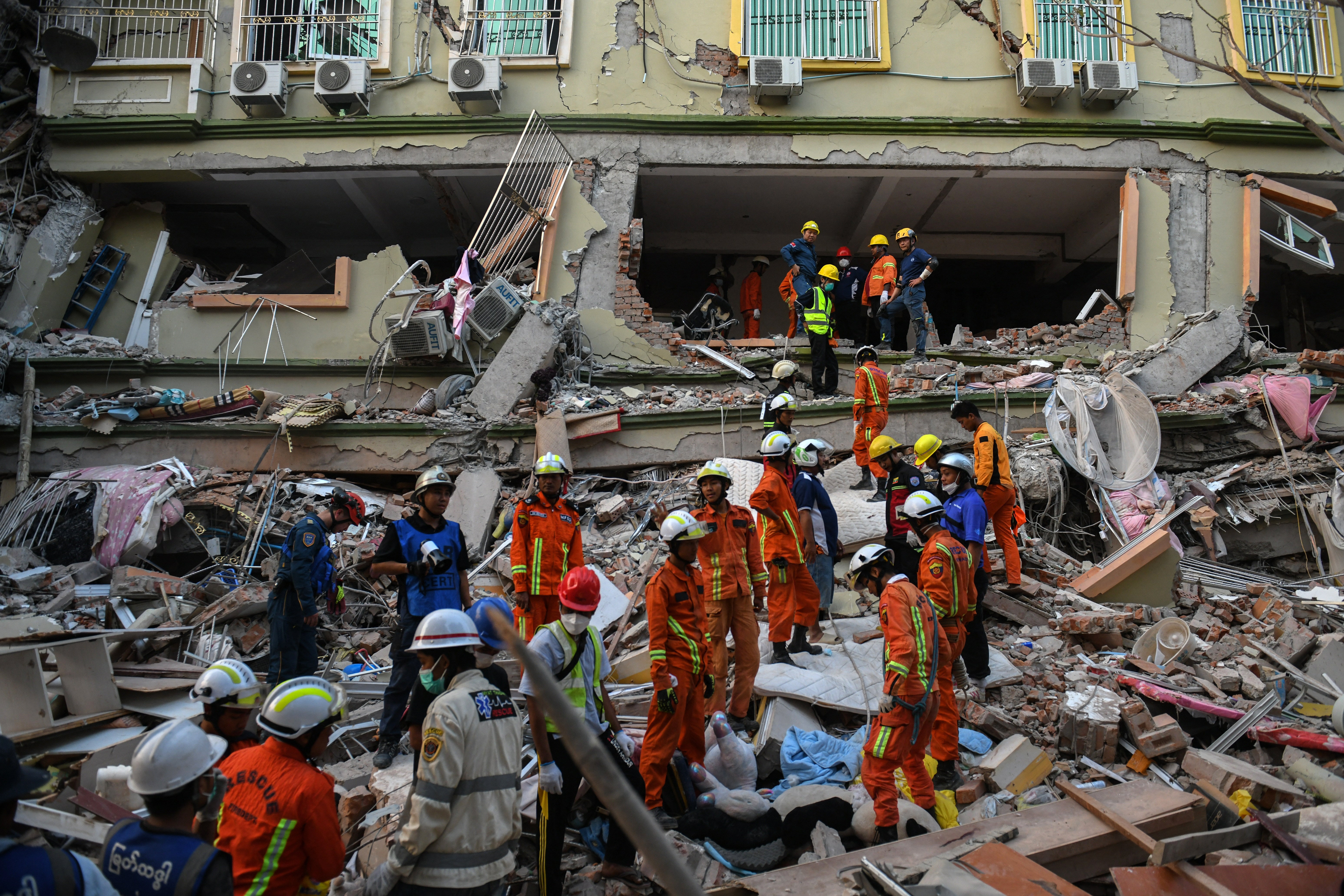 Rescue teams work to evacuate residents trapped under the rubble of collapsed building