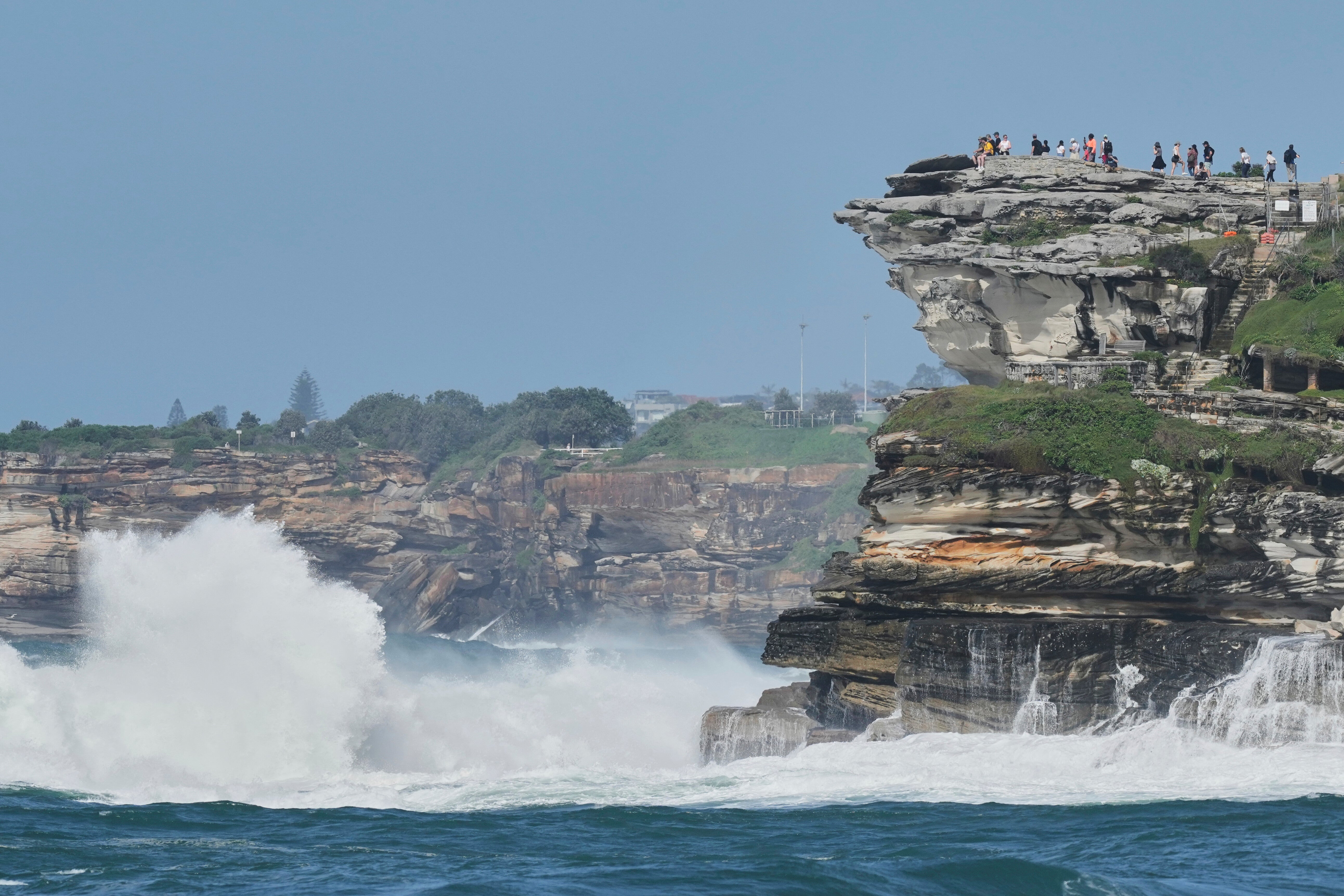 Crowds watch from the headland as large swells hit Sydney's Bondi Beach