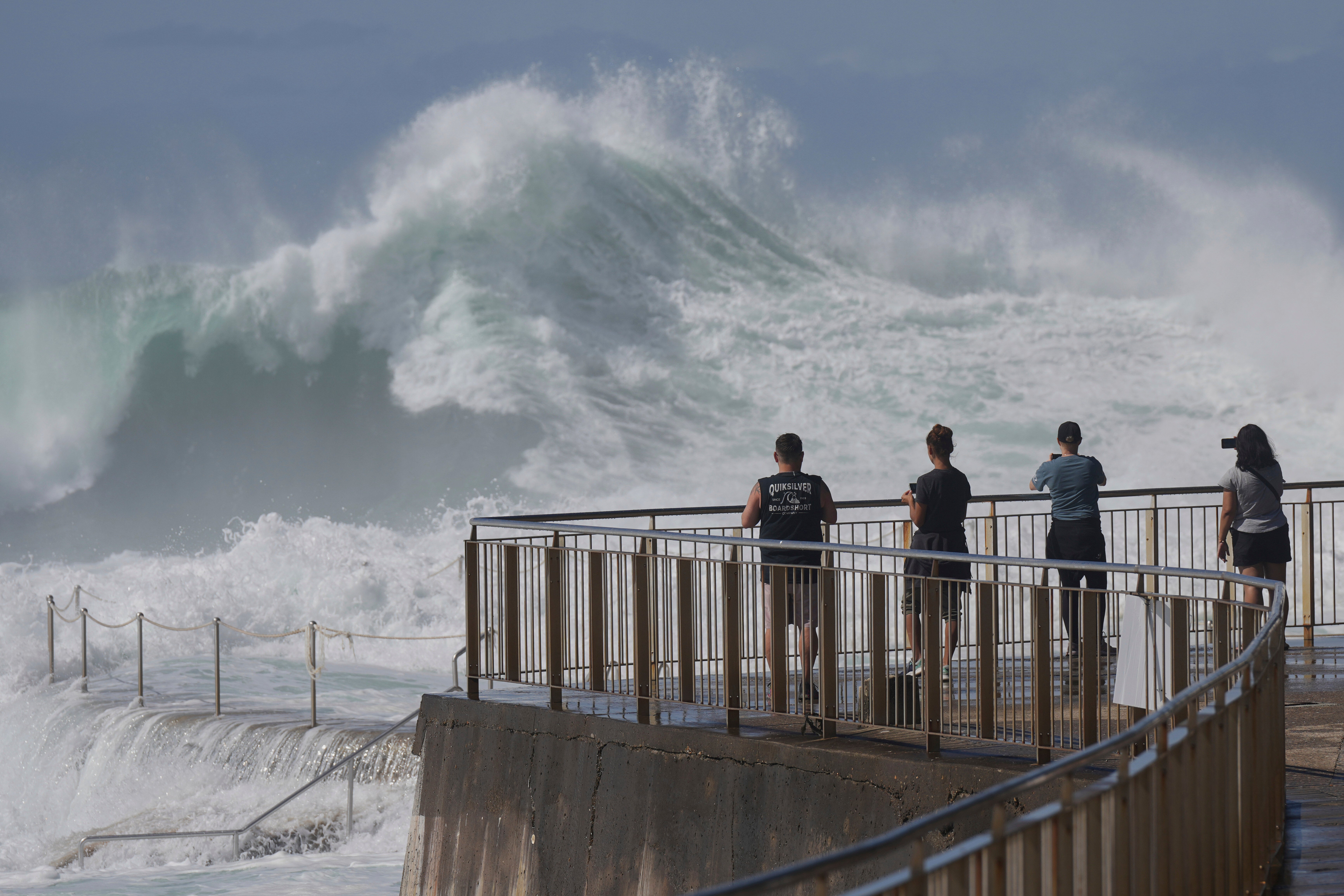People watch as large swells hit Sydney's Bronte Beach