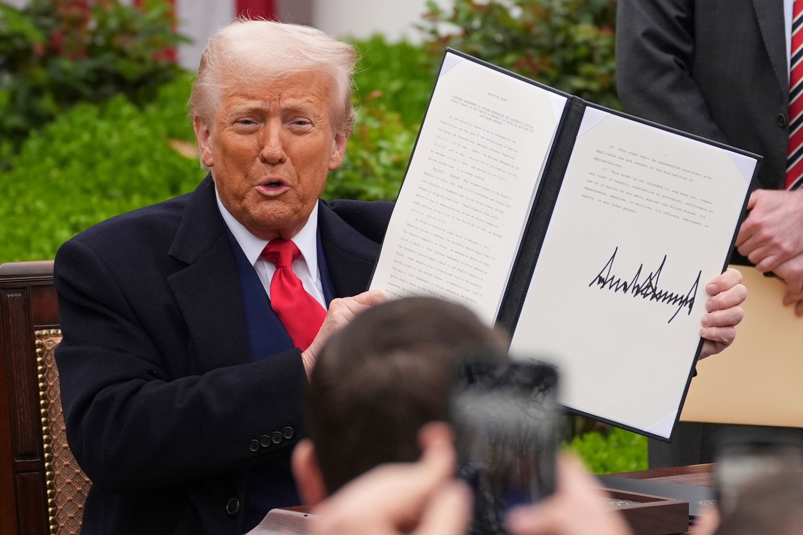 President Donald Trump holds a signed executive order (Evan Vucci/AP)