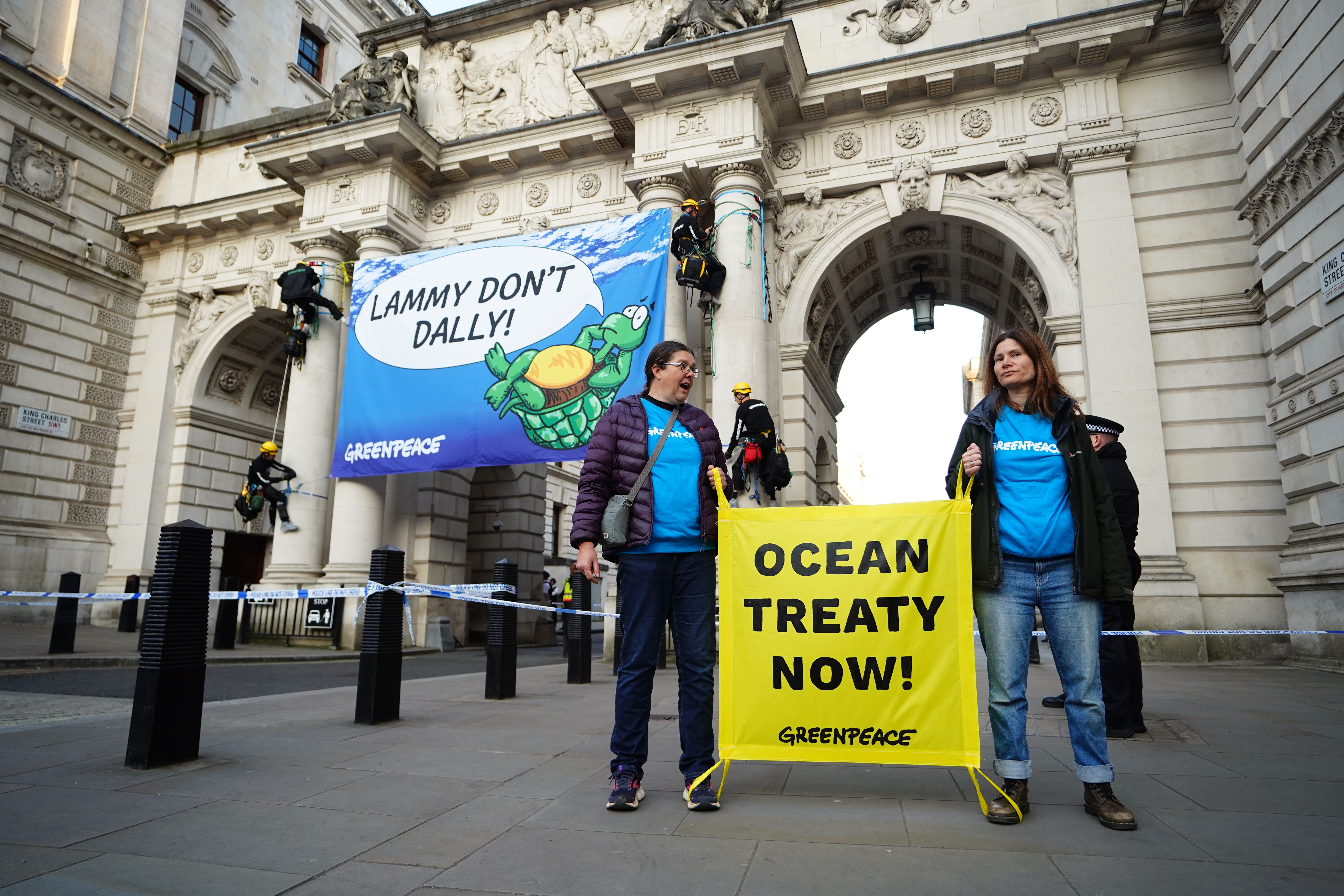 The activists unfurled a banner over the archway outside the Foreign Office (James Manning/PA)