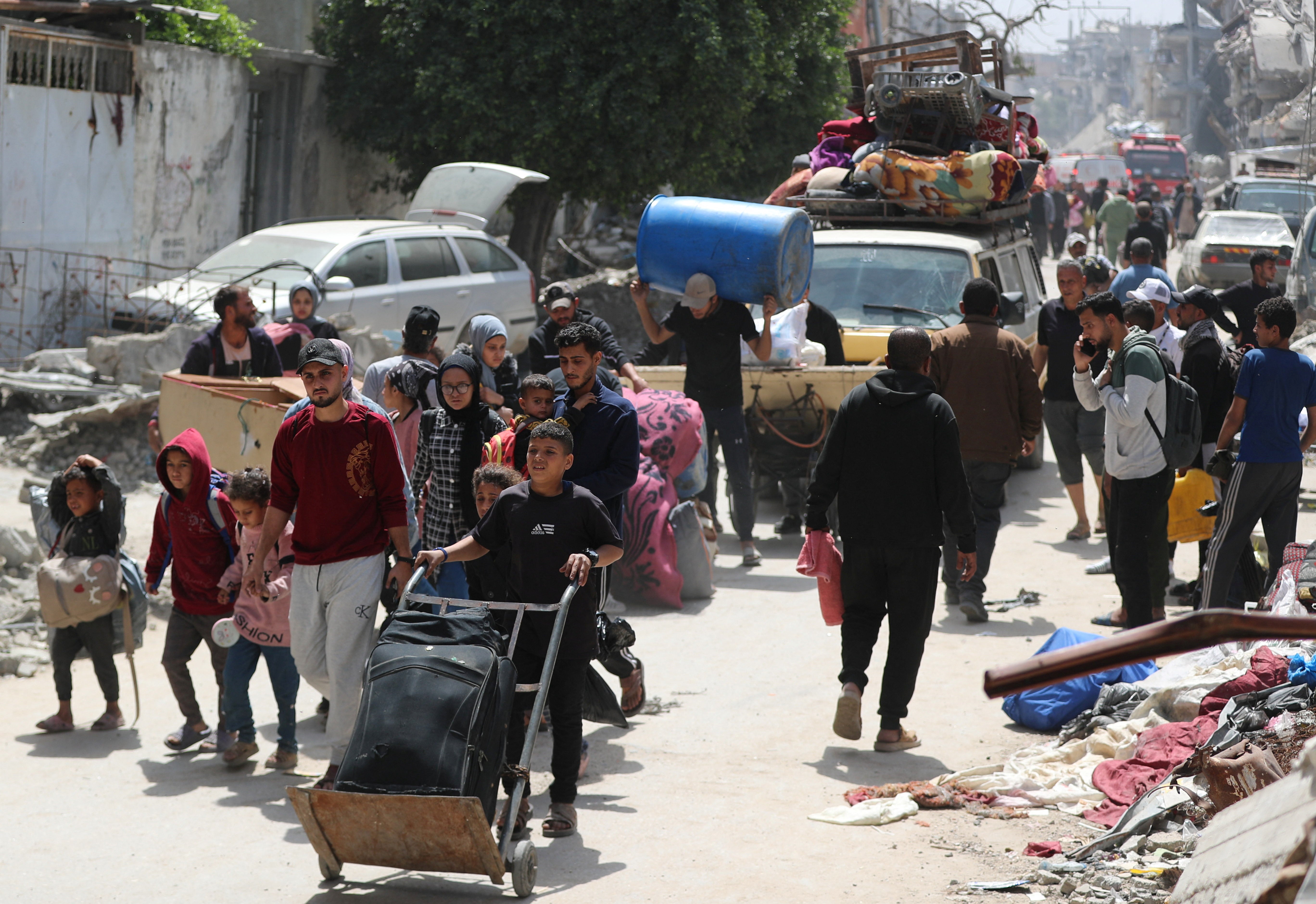 Palestinians make their way with belongings as they flee their homes, after the Israeli army issued evacuation orders, in the Shujaiya neighborhood of Gaza City
