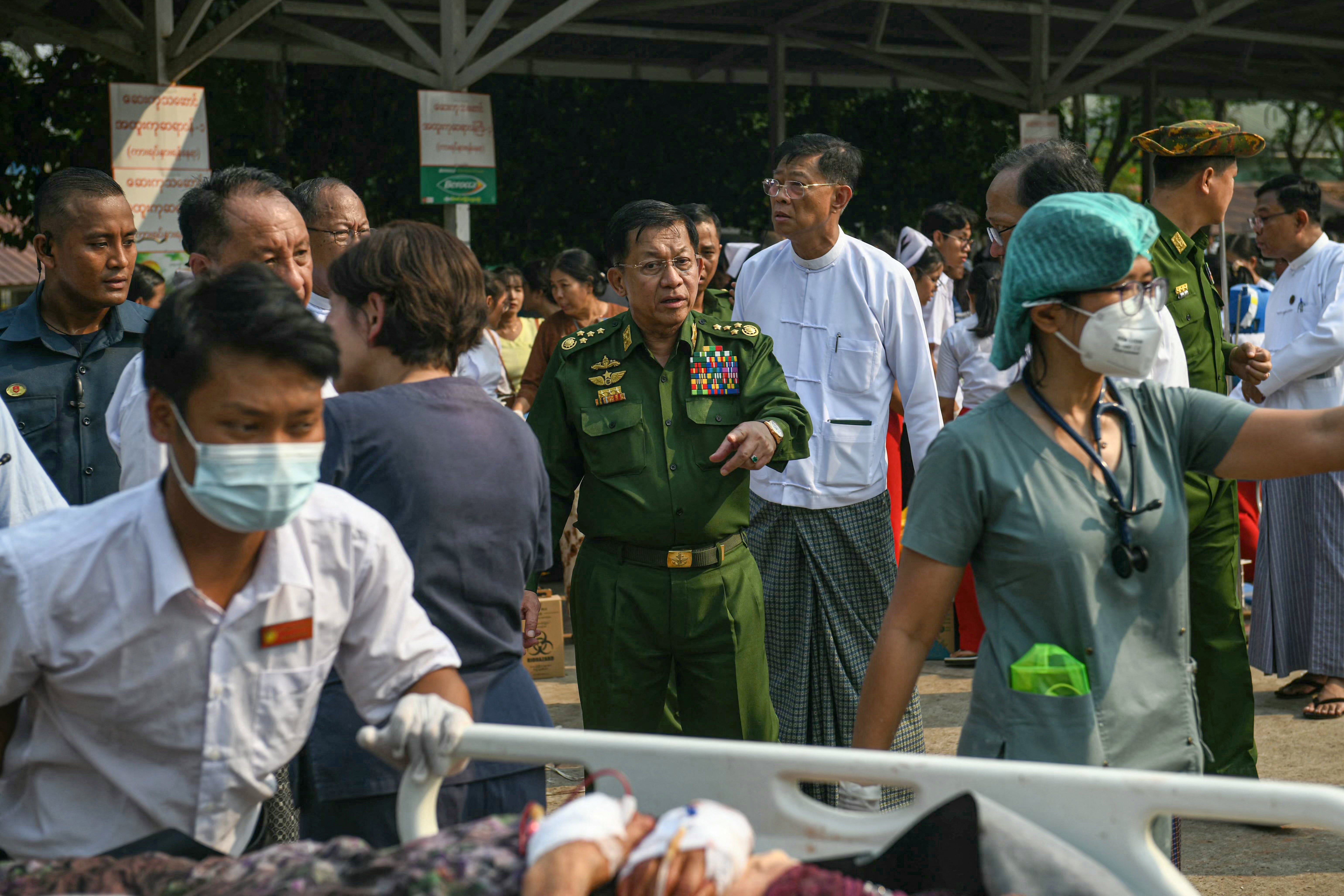 Myanmar's military chief Min Aung Hlaing gestures as earthquake survivors gather in the compound of a hospital in Naypyidaw