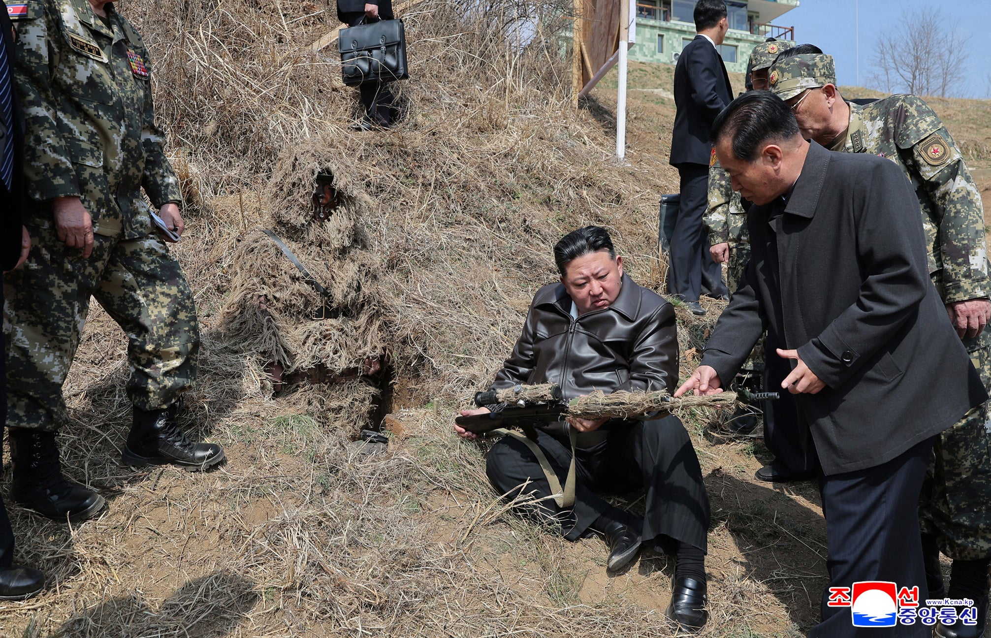 A photo released by the official North Korean Central News Agency (KCNA) shows Kim Jong Un test firing a sniper rifle during a visit to the training base
