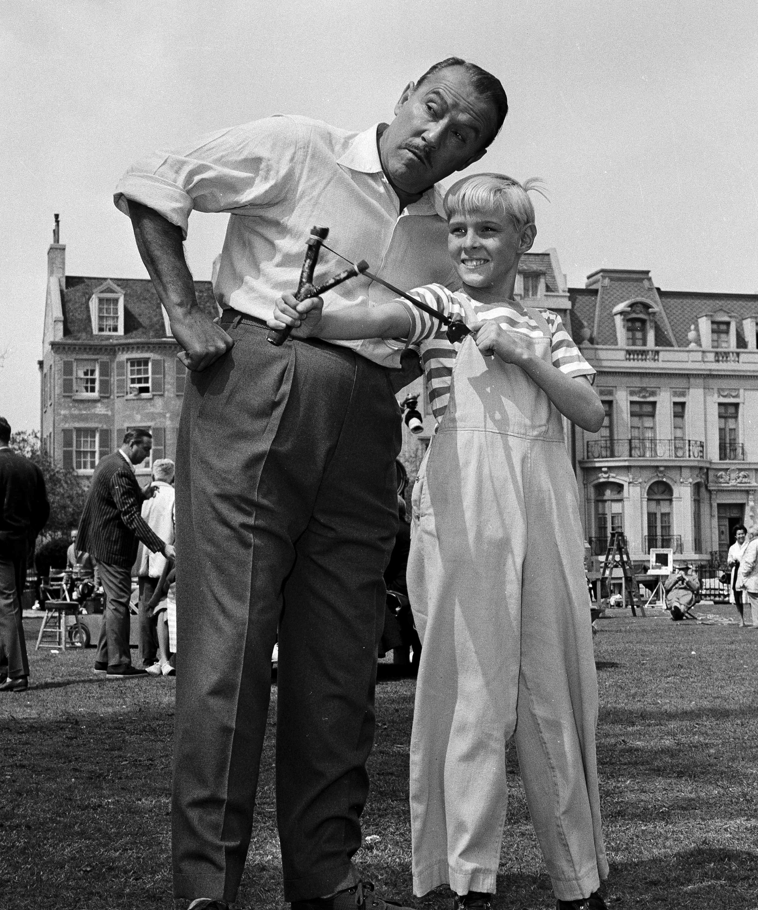 Actor Jay North, in character as Dennis the Menace, shows his ever-present slingshot to co-star Gale Gordon on set in 1962