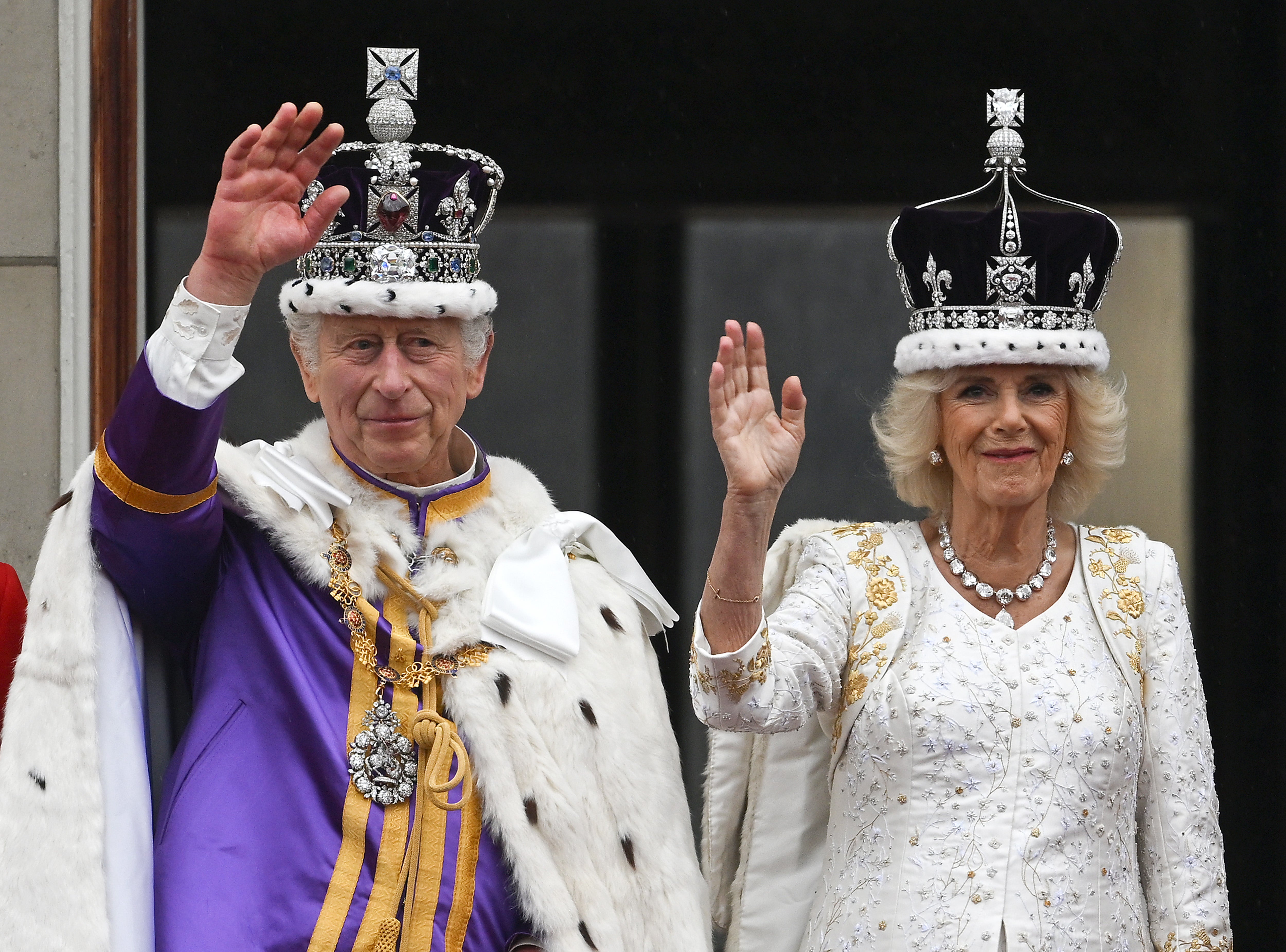 King Charles III and Queen Camilla wave from the Buckingham Palace balcony during their coronation on 6 May 2023