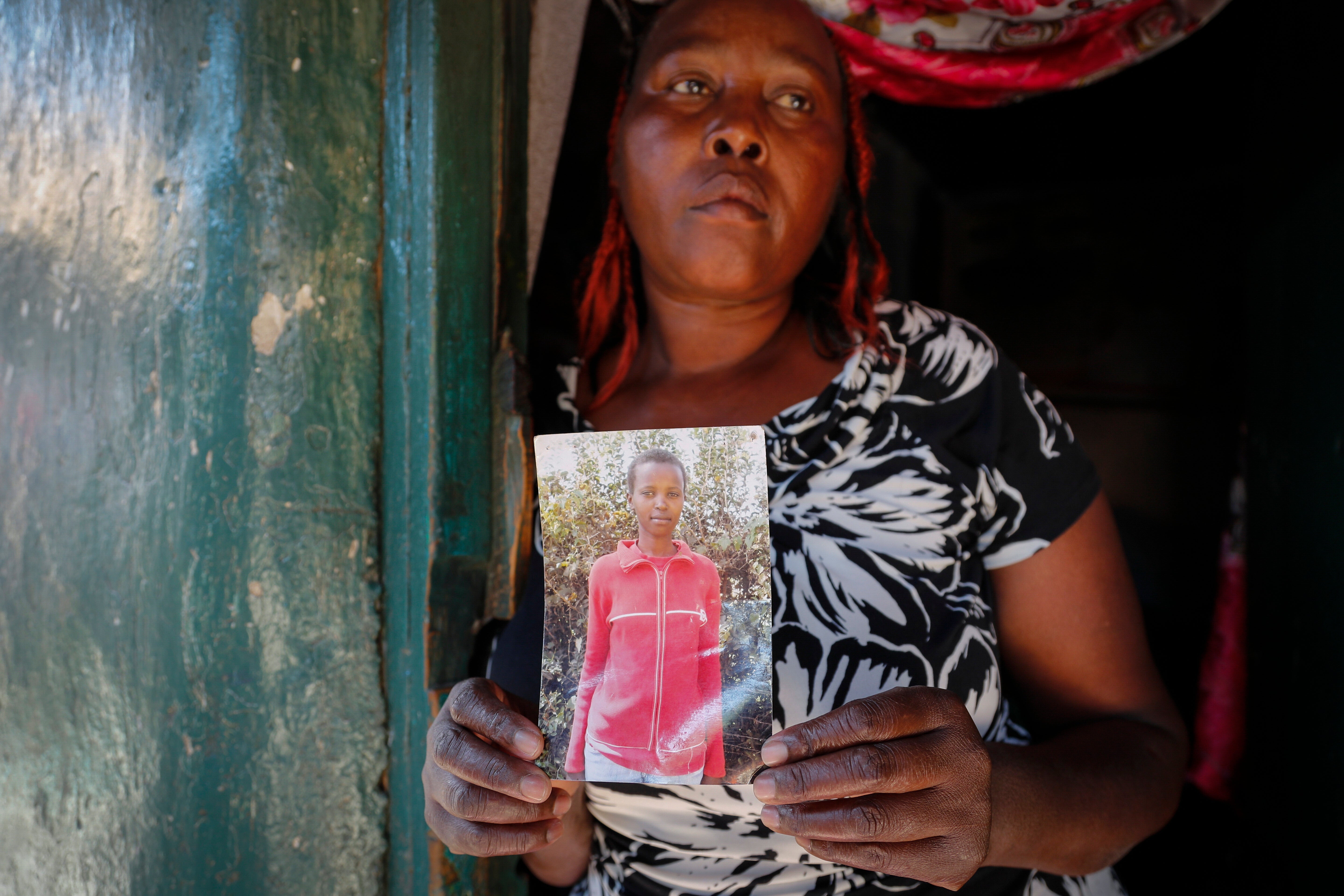 Rose Wanyua Wanjiku holds a photo of her younger sister, Agnes