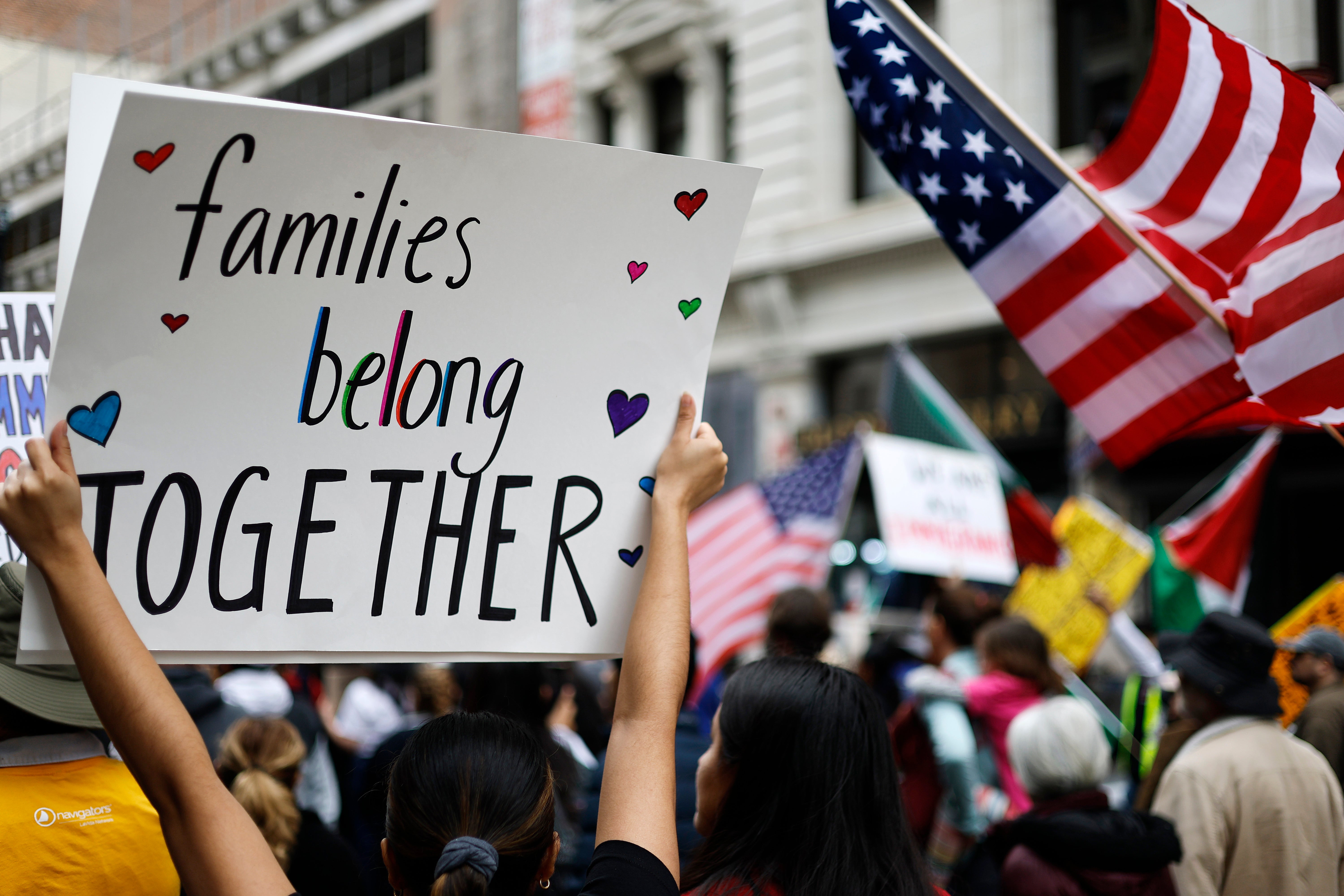 A demonstrator carries a sign reading 'Families Belong Together' at a march last month for immigrant rights