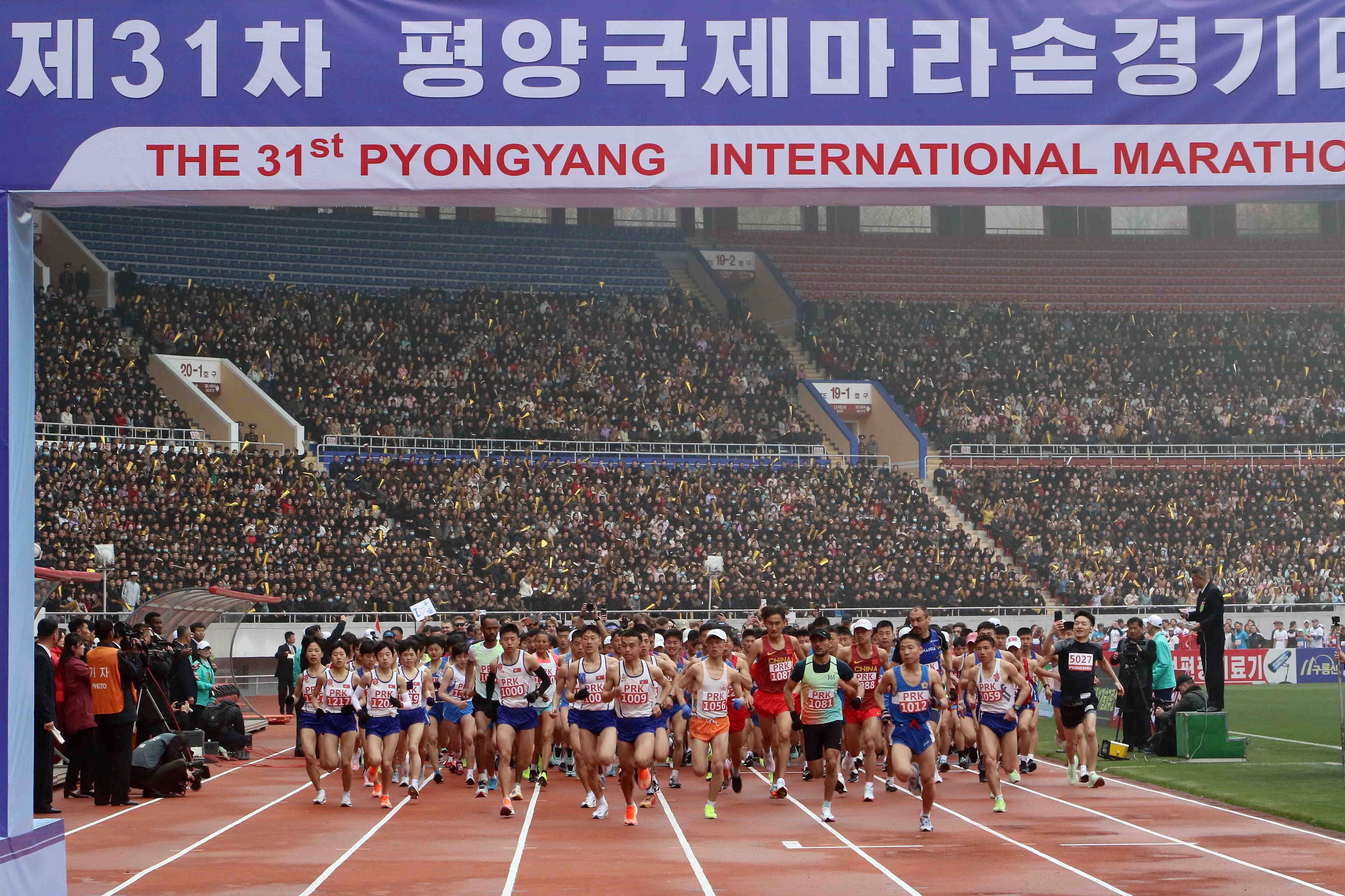 Spectators watch as runners take part in the Pyongyang marathon