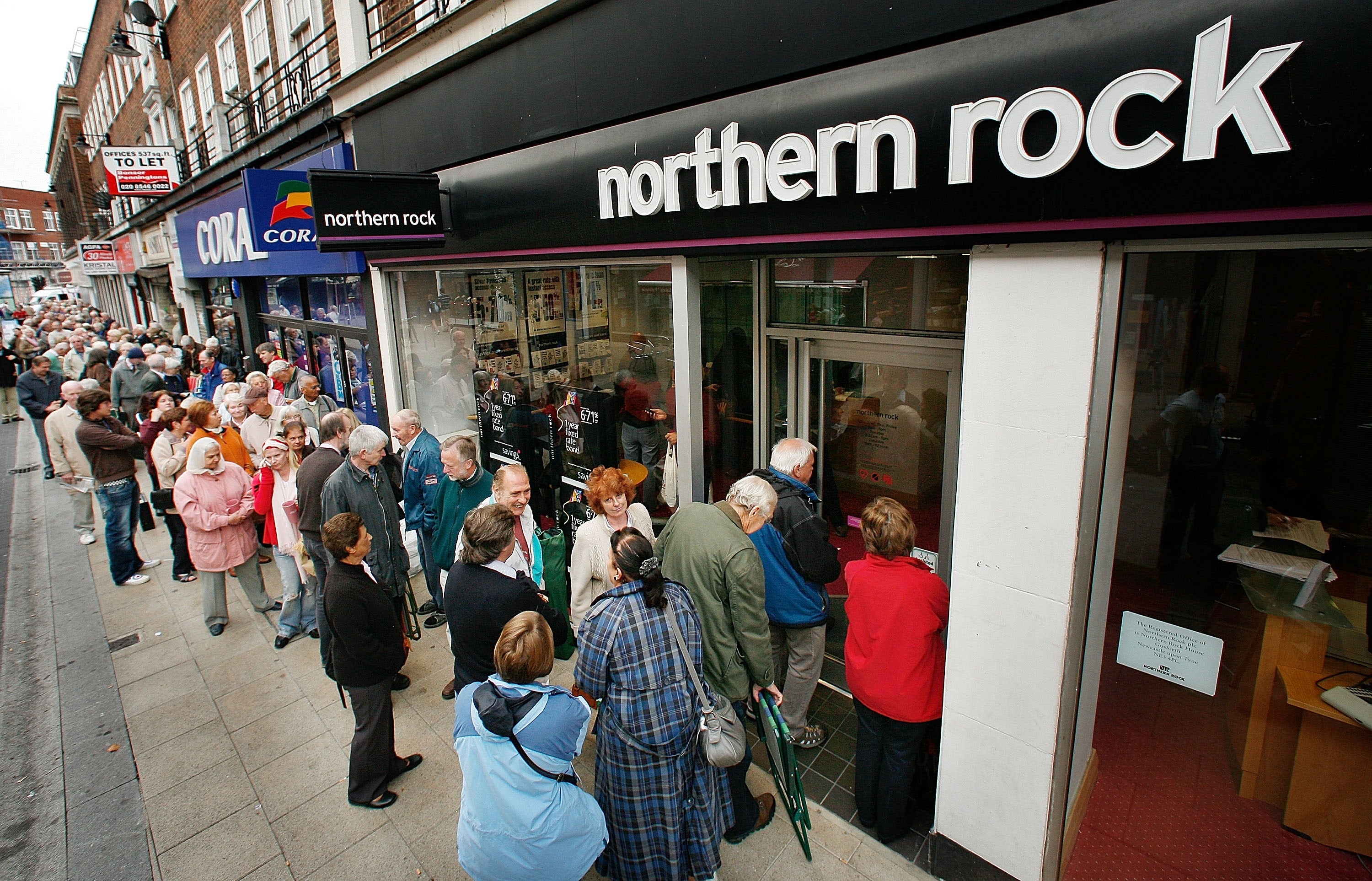 Customers wait in line to remove their savings from a branch of Northern Rock in Kingston in 2007