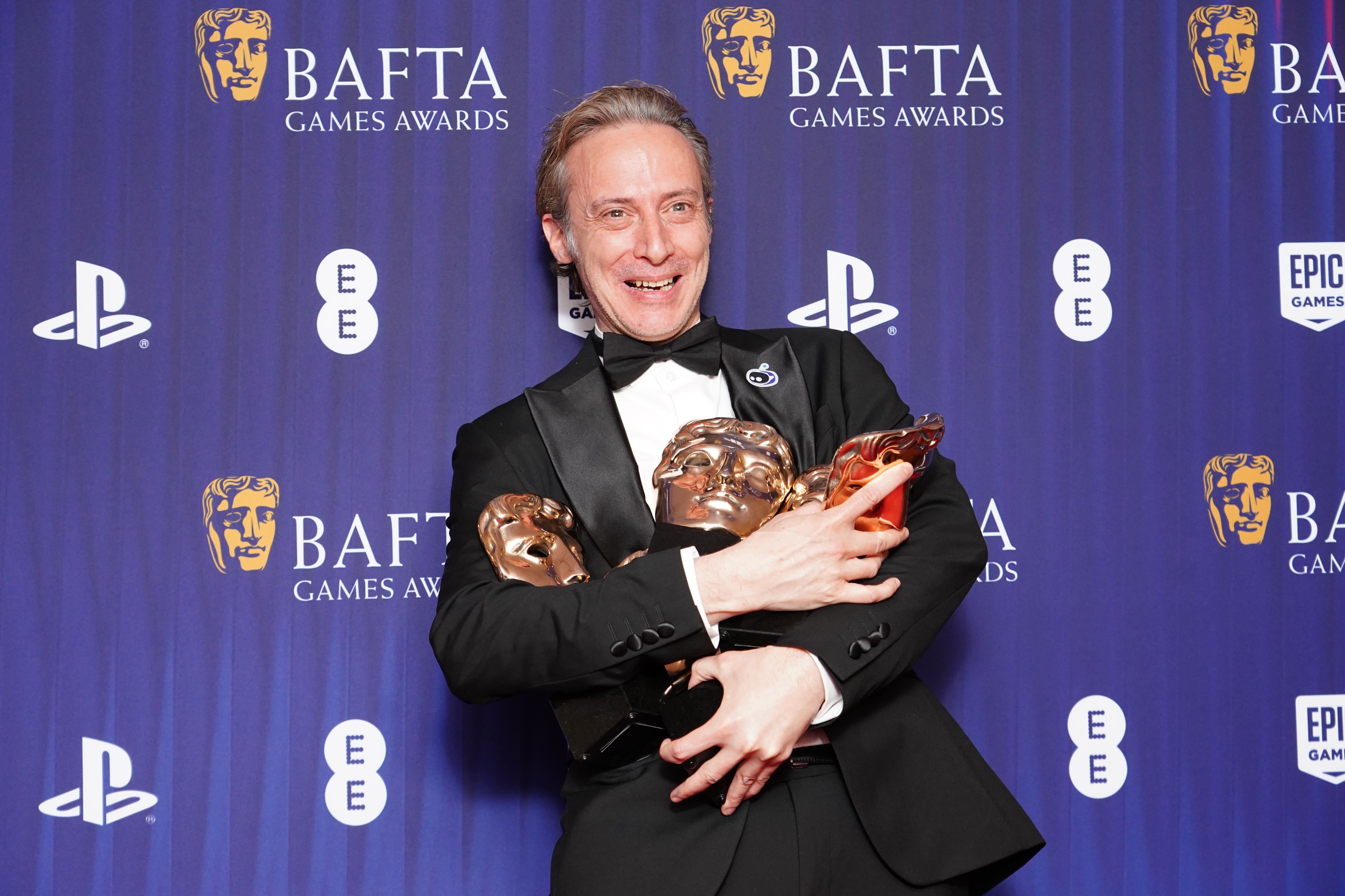 Nicholas Doucet with his five awards for Astro Bot – audio achievement, family game, animation, game design and best game – at the Bafta Games Awards 2025 (Ian West/PA)