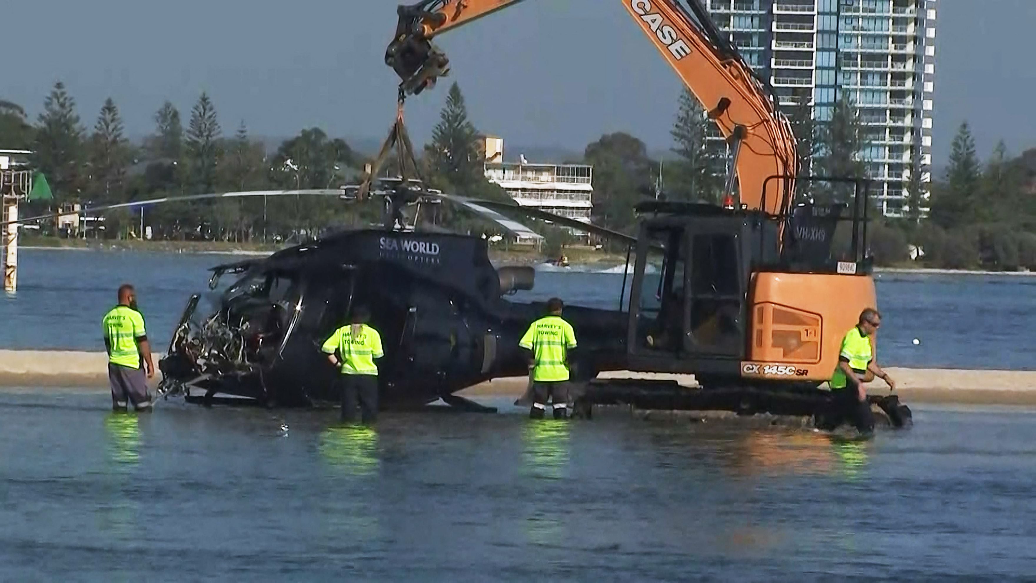 Airport workers prepare to remove one of the helicopters after the midair collision