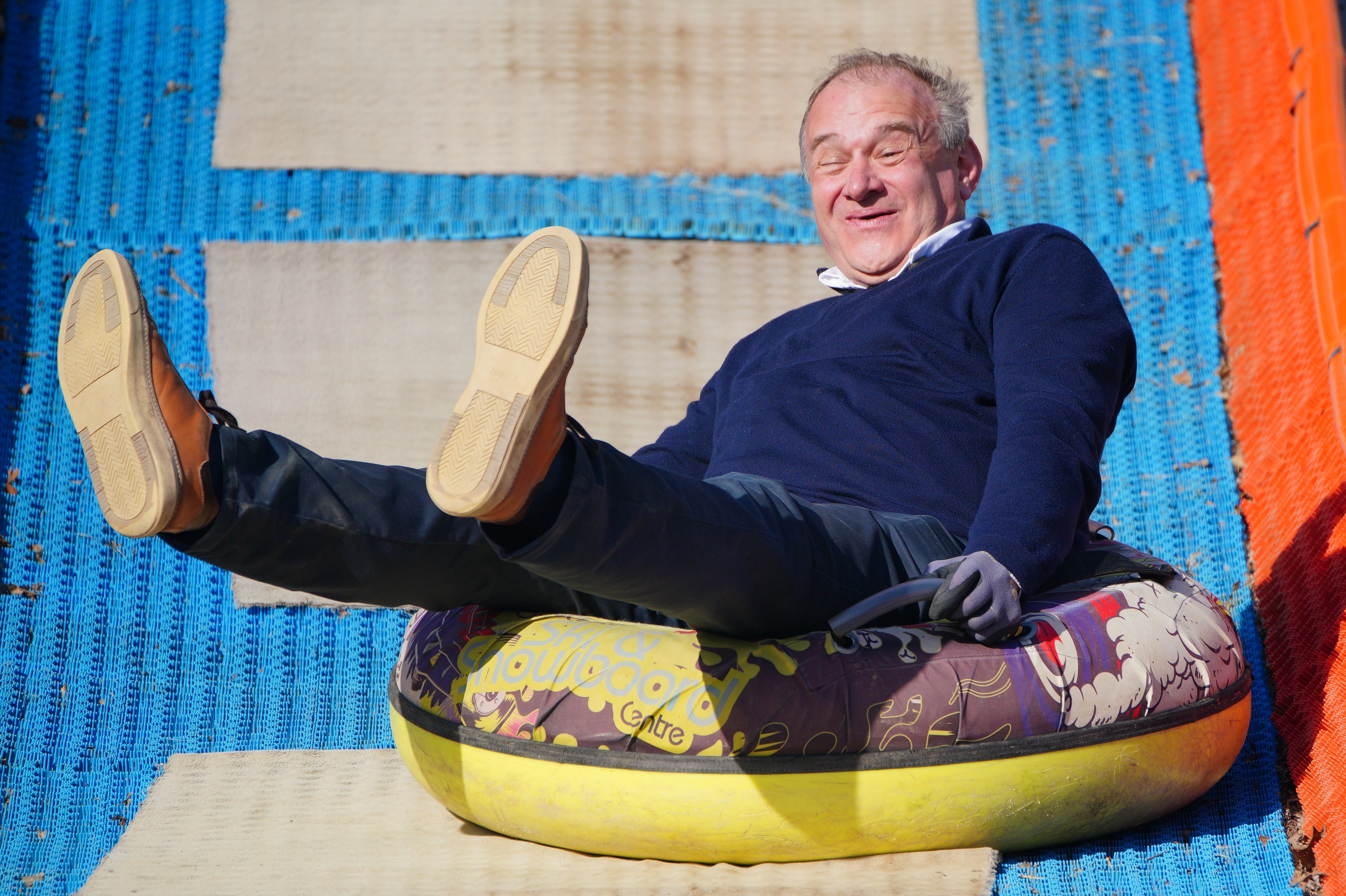 Liberal Democrat leader Sir Ed Davey skidded down a steep slope in a rubber ring to demand smoother road surfaces for motorists to glide over