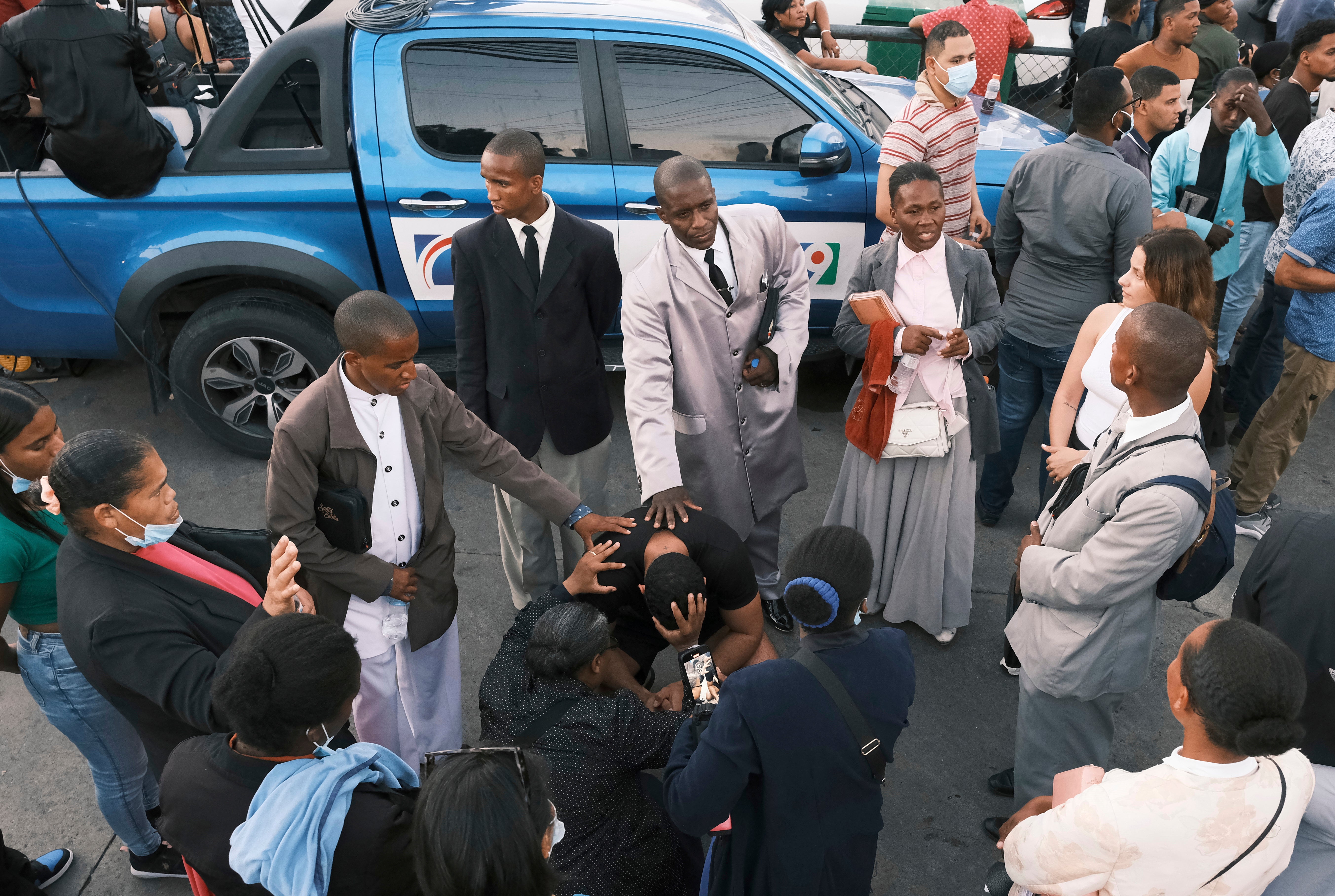 People pray for their missing relatives outside Jet Set nightclub