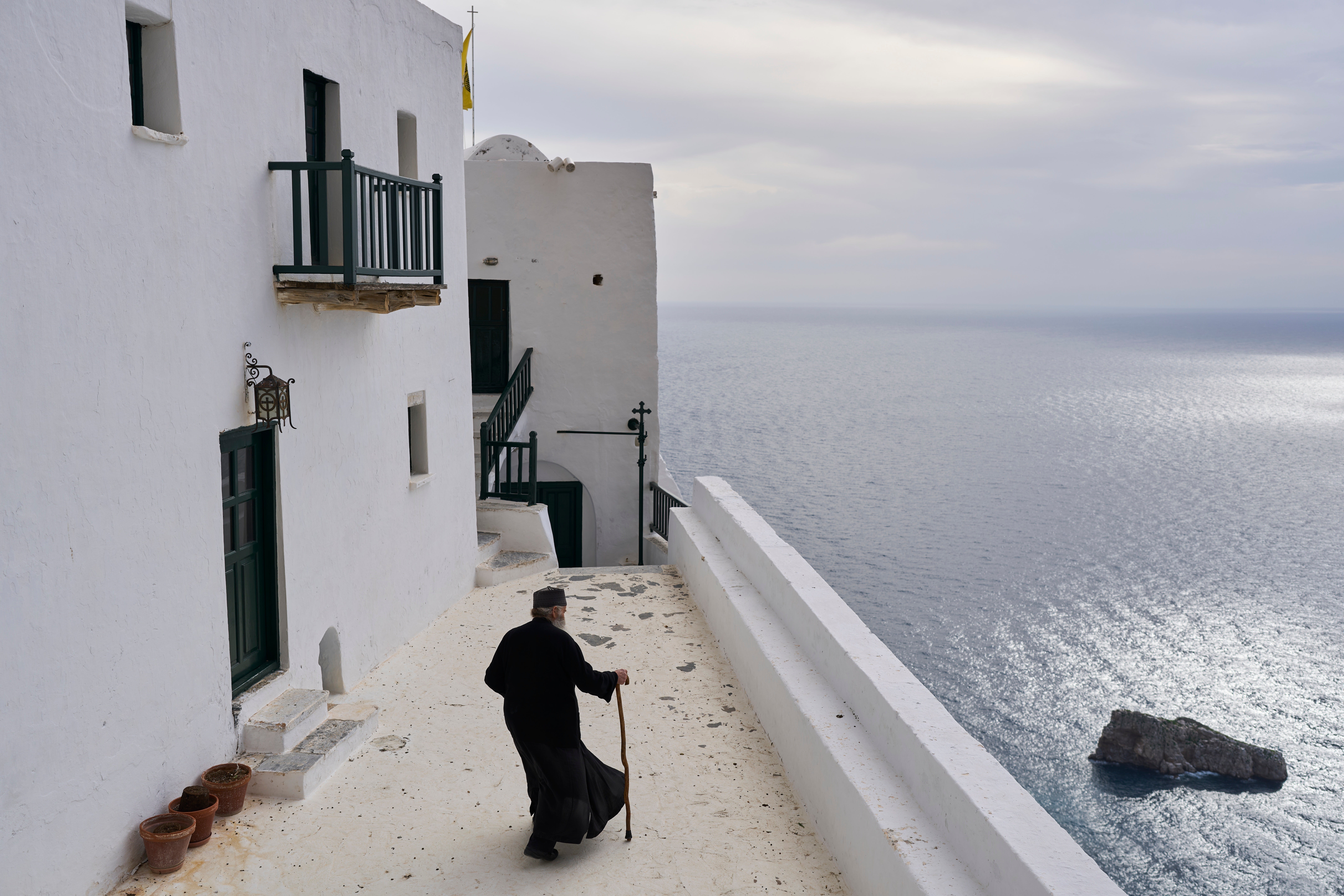 Orthodox Christian monk Father Spyridon walks at the Monastery of Panagia Hozoviotissa along the Aegean Sea