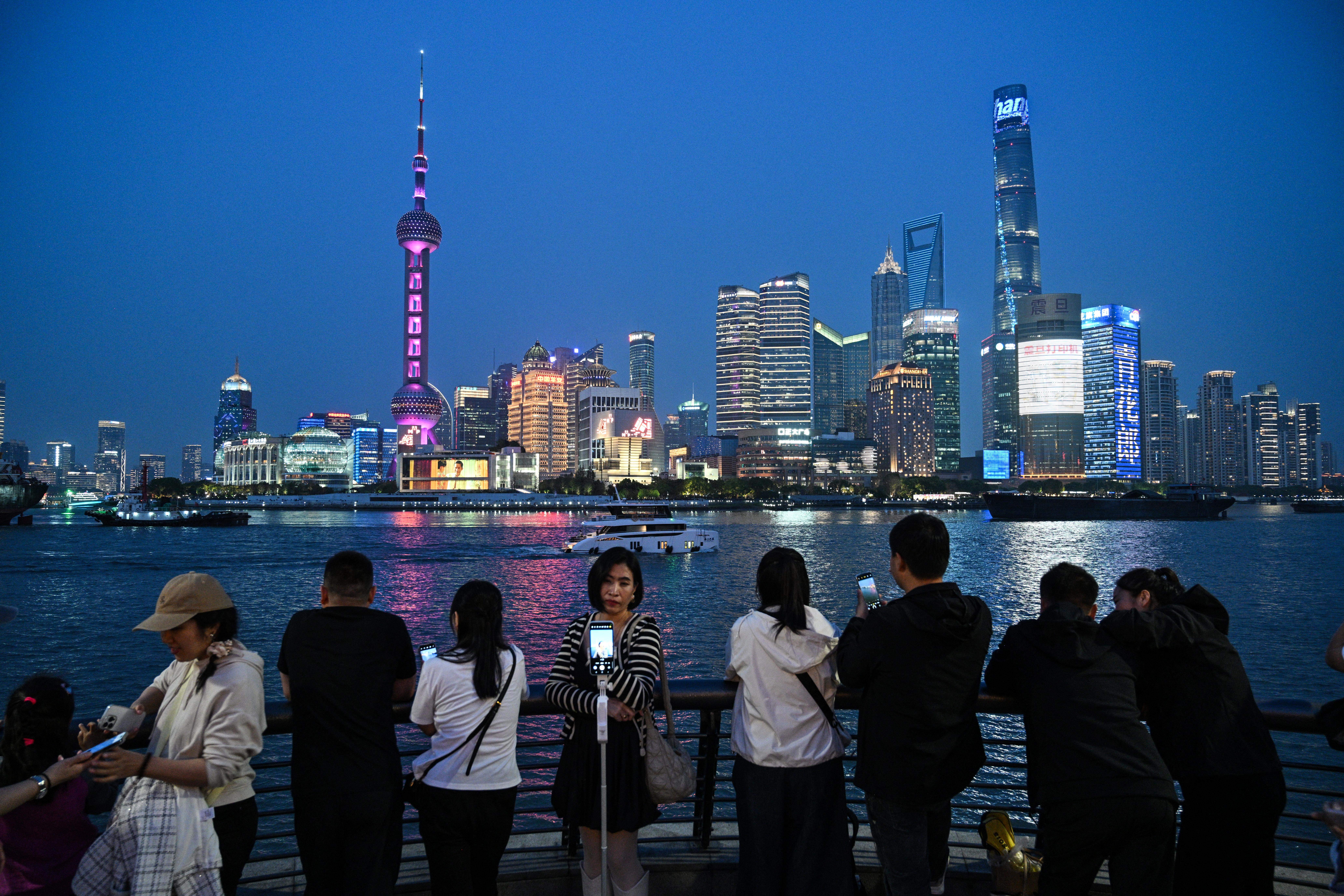 People visit The Bund promenade along the Huangpu river in Shanghai