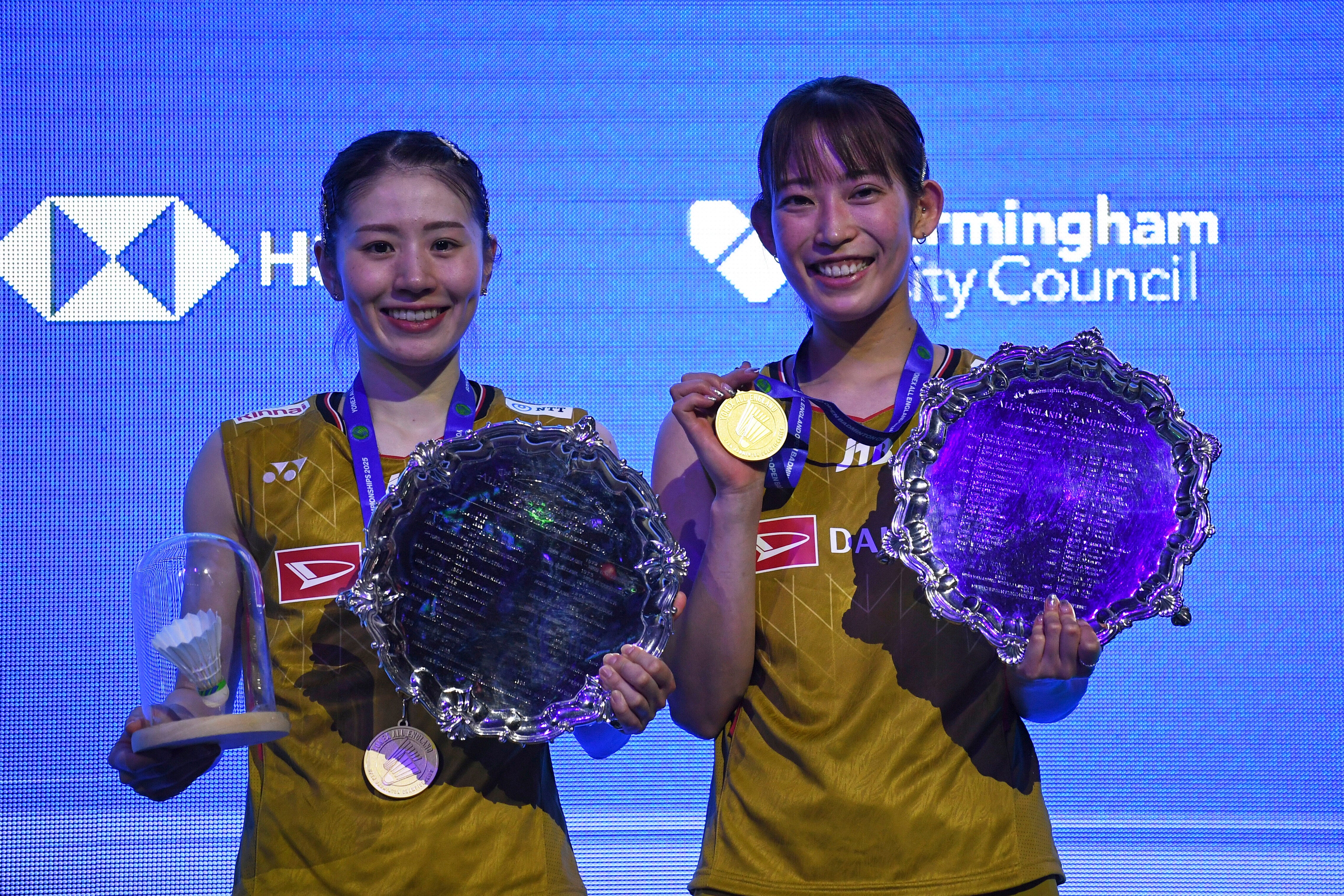 Japan's Chiharu Shida, left, and her partner Nami Matsuyama pose on the podium after defeating Japan's Mayu Matsumoto and Yuki Fukushima in the women's doubles final match at the All England Open Badminton Championships