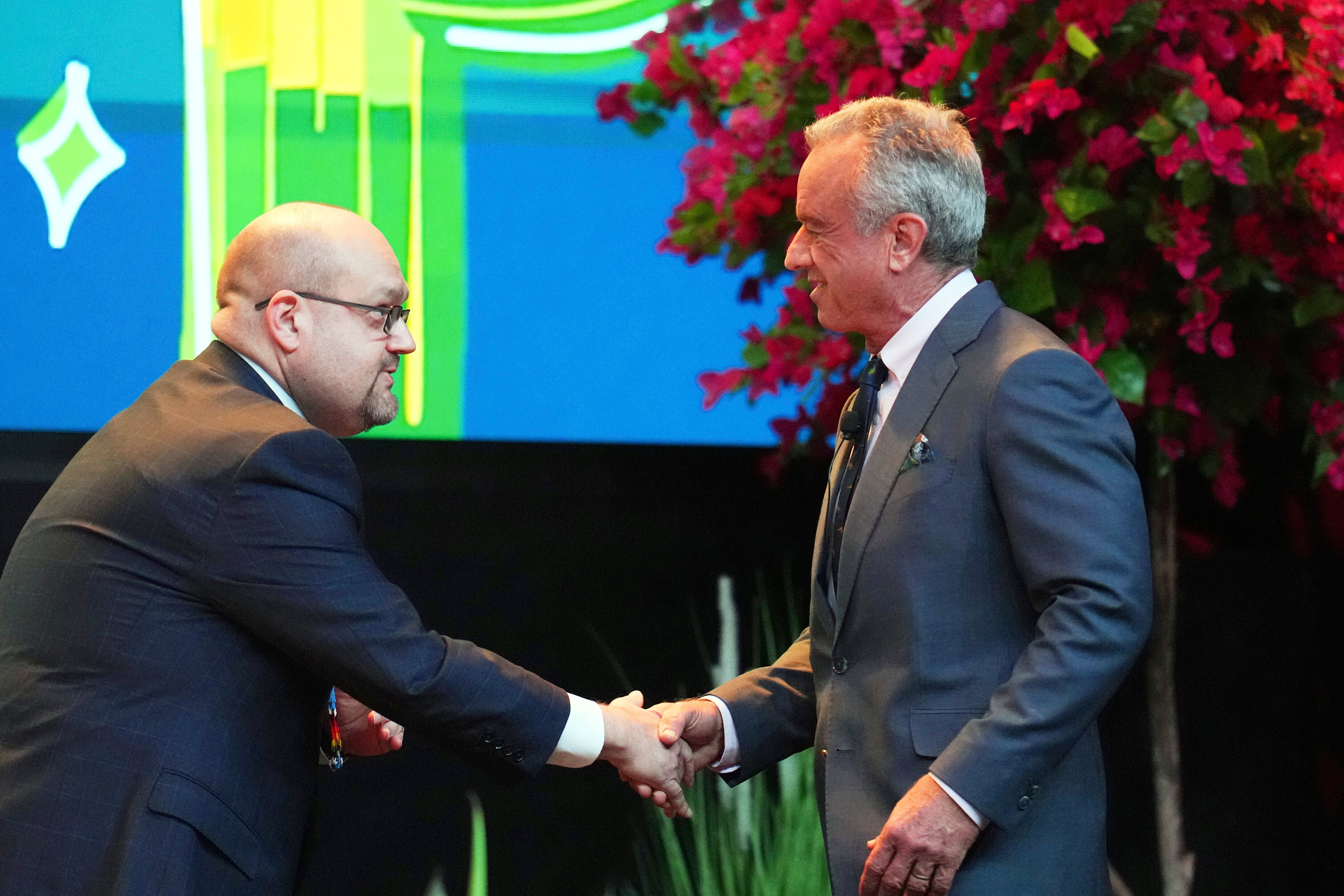 U.S. Health Secretary Robert F. Kennedy Jr., right, shakes hands with Chris Anoatubby, Lt. Gov., Chickasaw Nation prior to a Fireside Chat at the Tribal Self-Determination and Self-Governance Conference Tuesday, April 8, 2025, in Chandler, Ariz. (AP Photo/Ross D. Franklin)