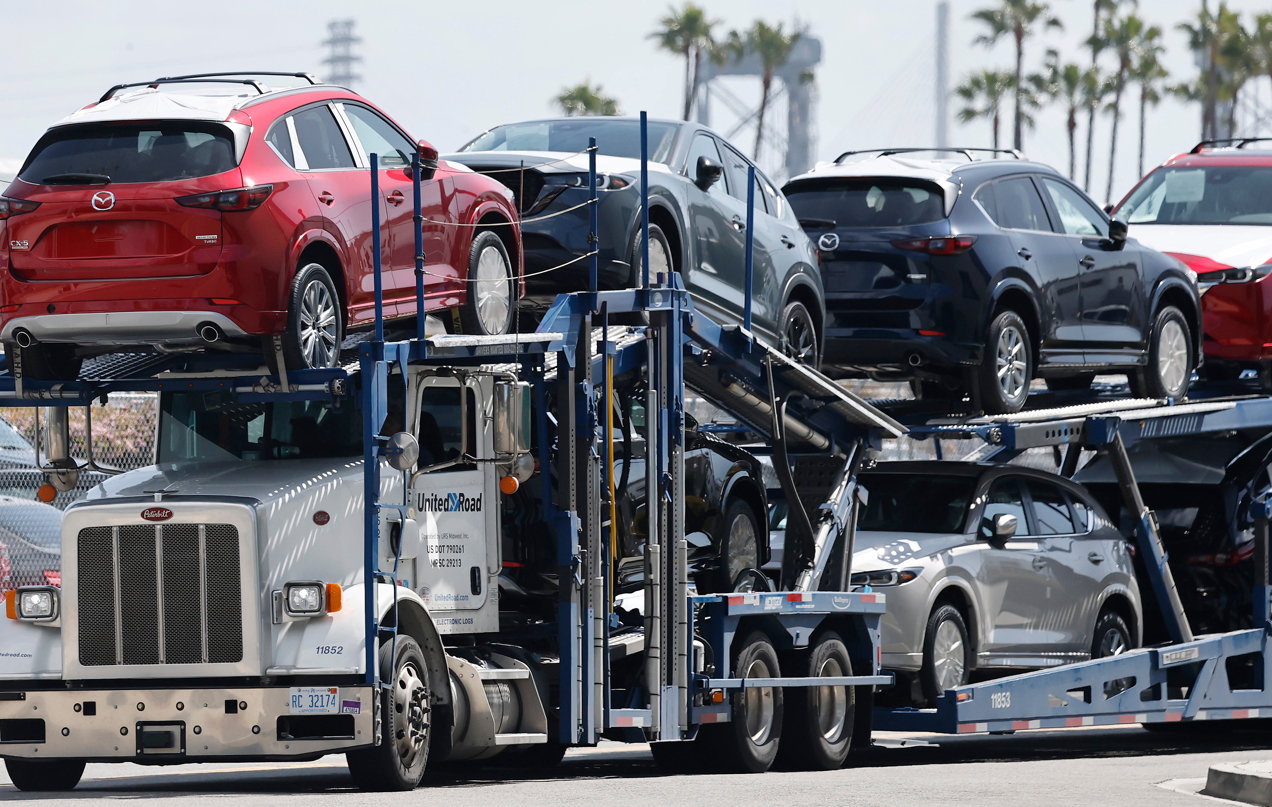 New Mazda cars are driven away from an automobile processing terminal on a car hauler at the Port of Los Angeles