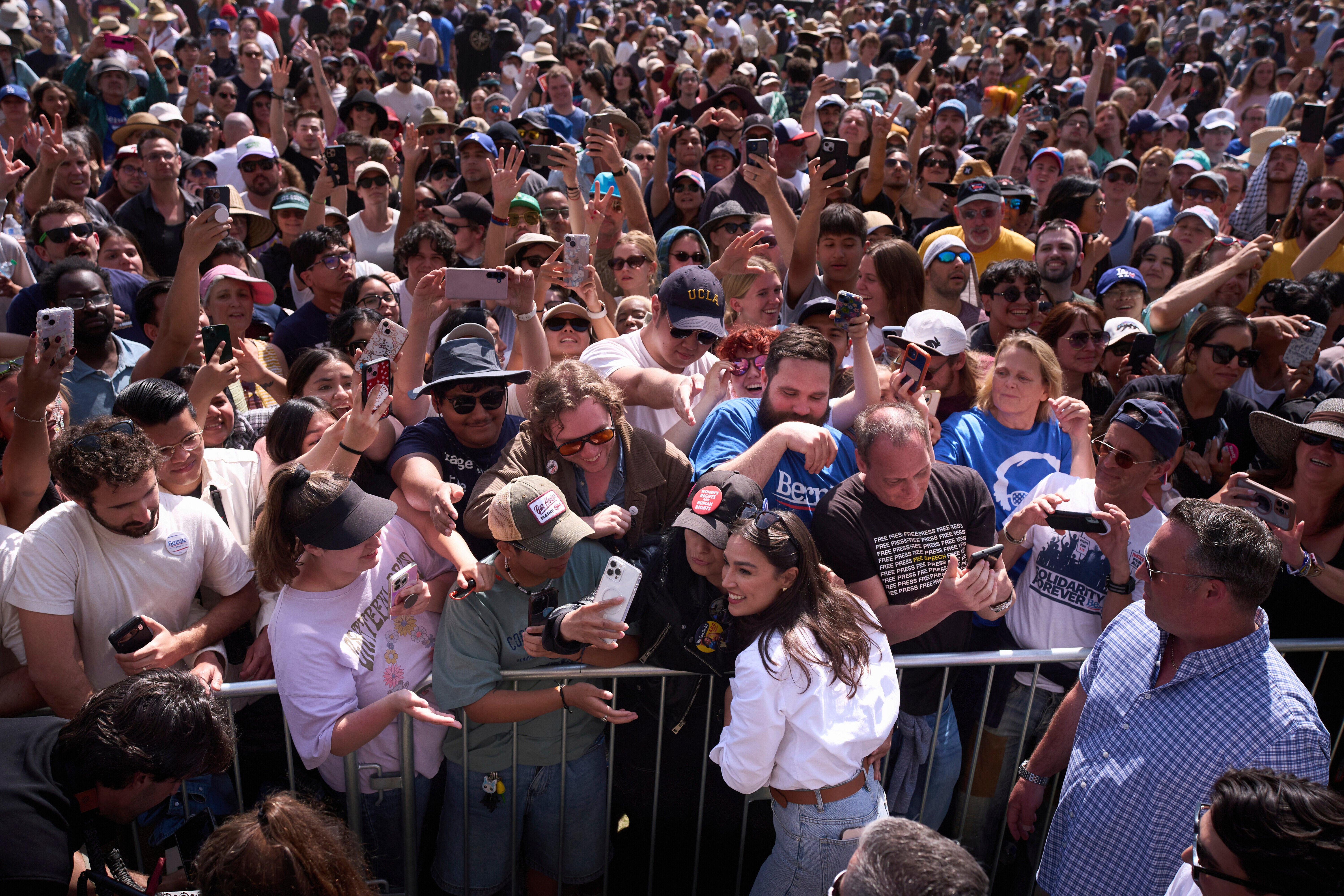 AOC Bernie Sanders pictured taking a selfie with supporters after a "Fighting Oligarchy" event in Los Angeles Saturday