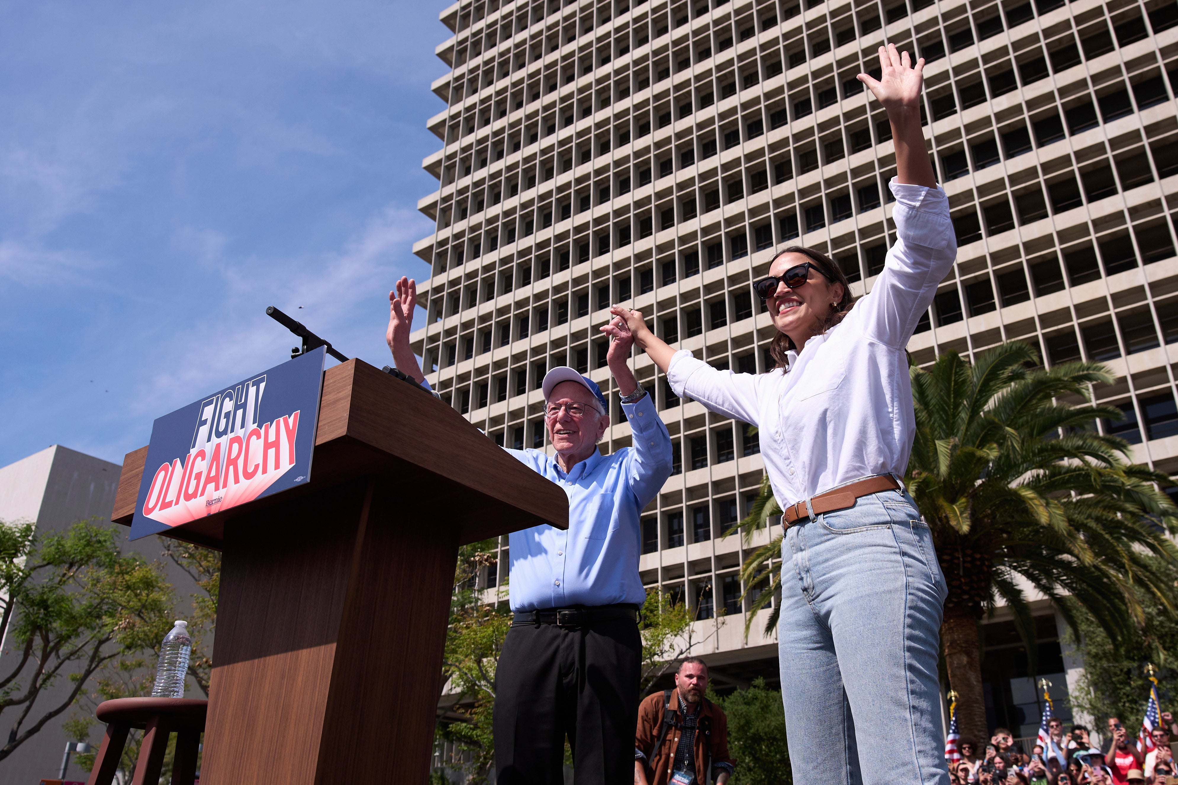 Bernie Sanders and Alexandria Ocasio-Cortez acknowledge the crowd at a ‘Fighting Oligarchy’ event in Los Angeles on April 12