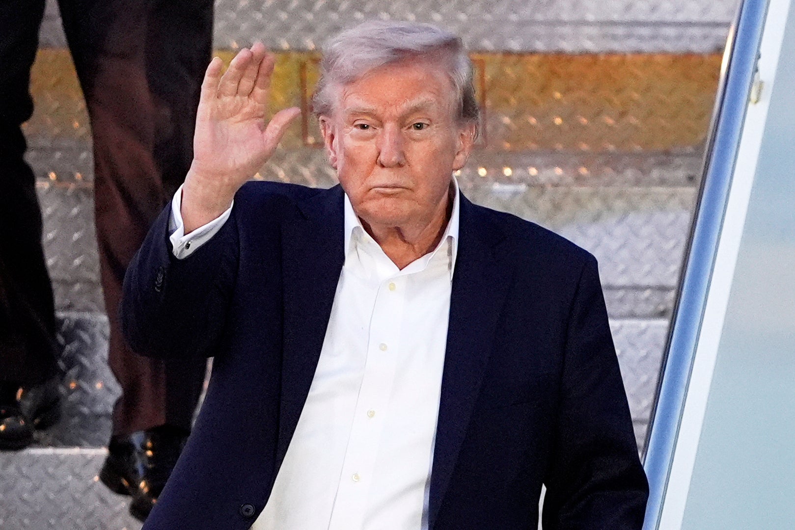 President Donald Trump waves as he steps off Air Force One. Some companies are already adding a ‘Trump tariff surcharge,’ according to new reports
