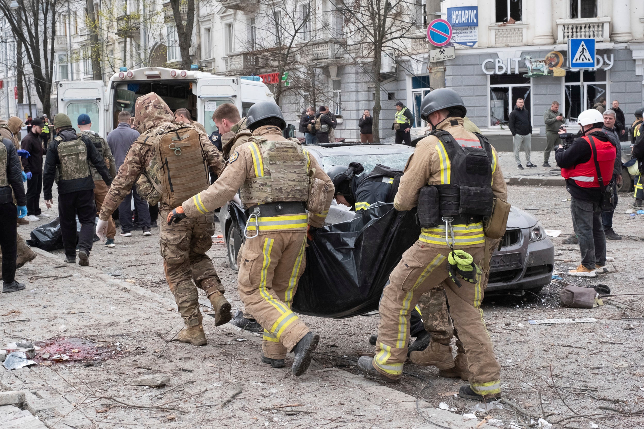 Service personnel carry bodies of victims away from the scene of the Palm Sunday attack